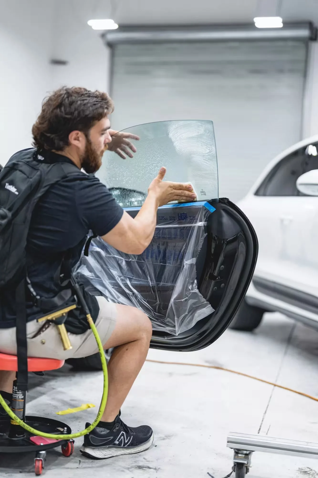 Technician installing XPEL ceramic window tint on a vehicle door window at Xtreme Car & Truck Accessories in Bridgeville, PA, serving Pittsburgh and the South Hills.