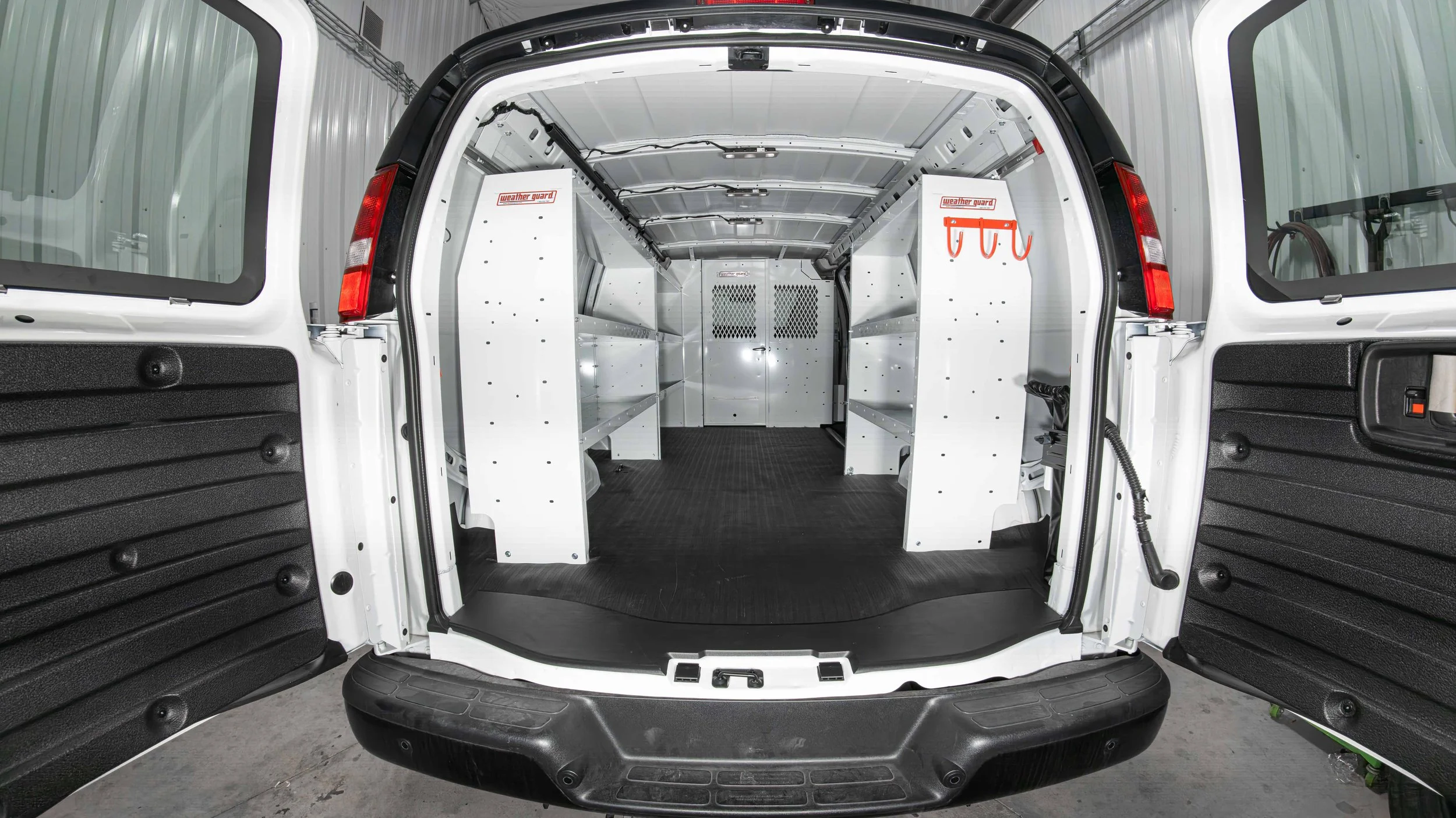 Straight-on rear view of a completed WeatherGuard van shelving install with shelves on both sides of a Chevy Express