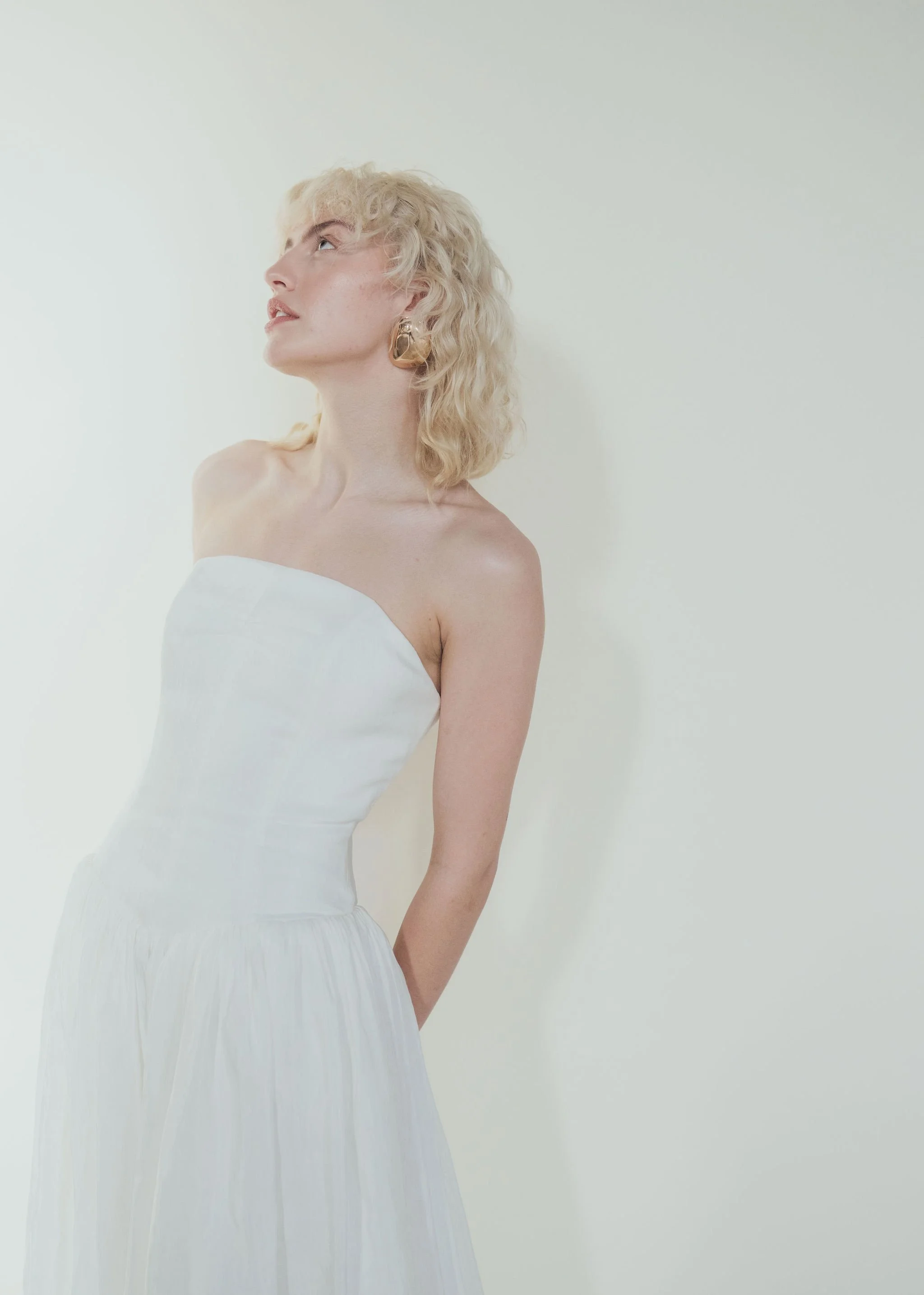 A professional makeup artist working in North Yorkshire, creating soft, natural bridal makeup. Close-up of glowing, dewy skin, warm rose blush, subtle neutral eyeshadow with fine shimmer, softly defined lashes, and a fresh nude-pink lip. 