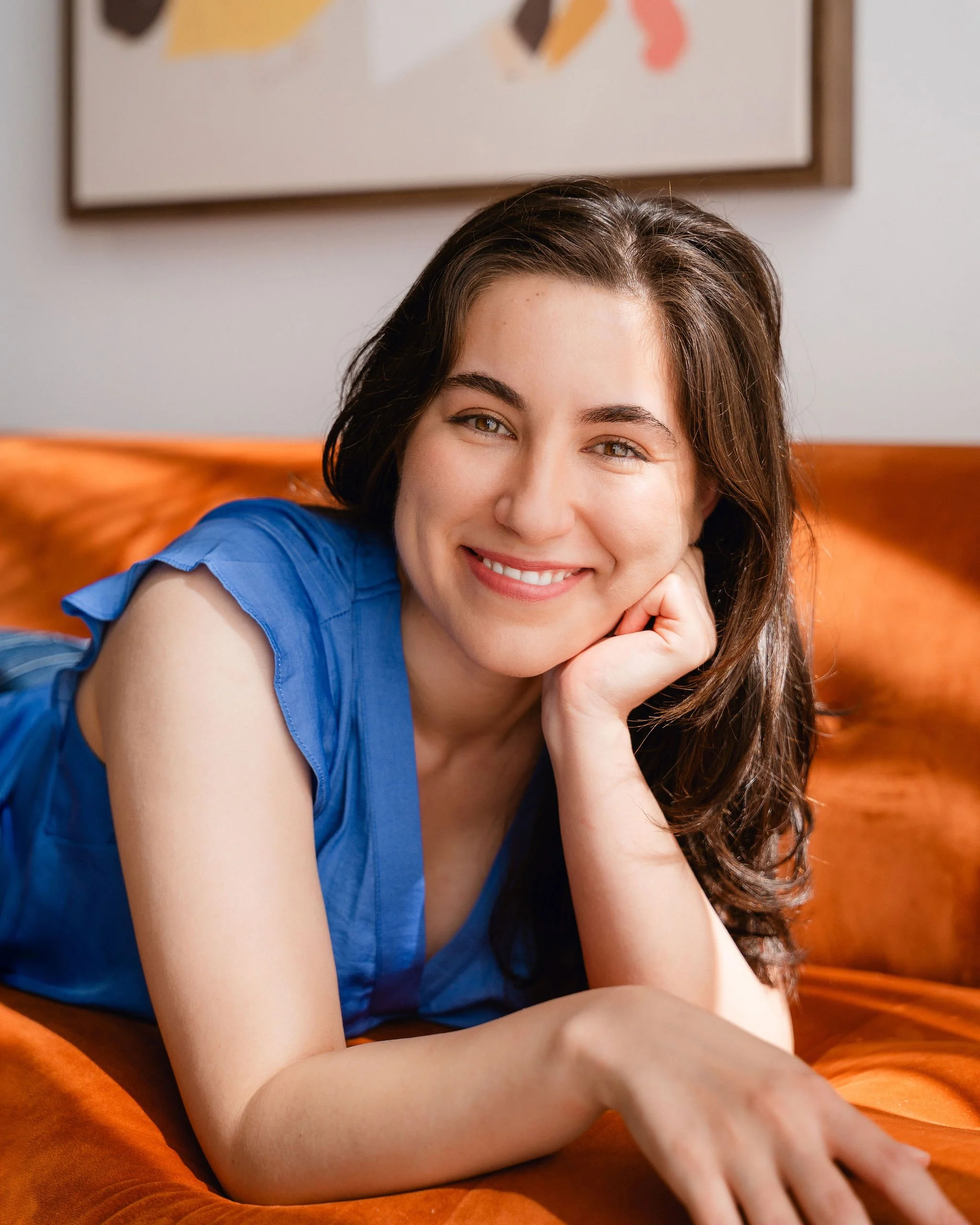 Monauar smiling with her head resting on her hand