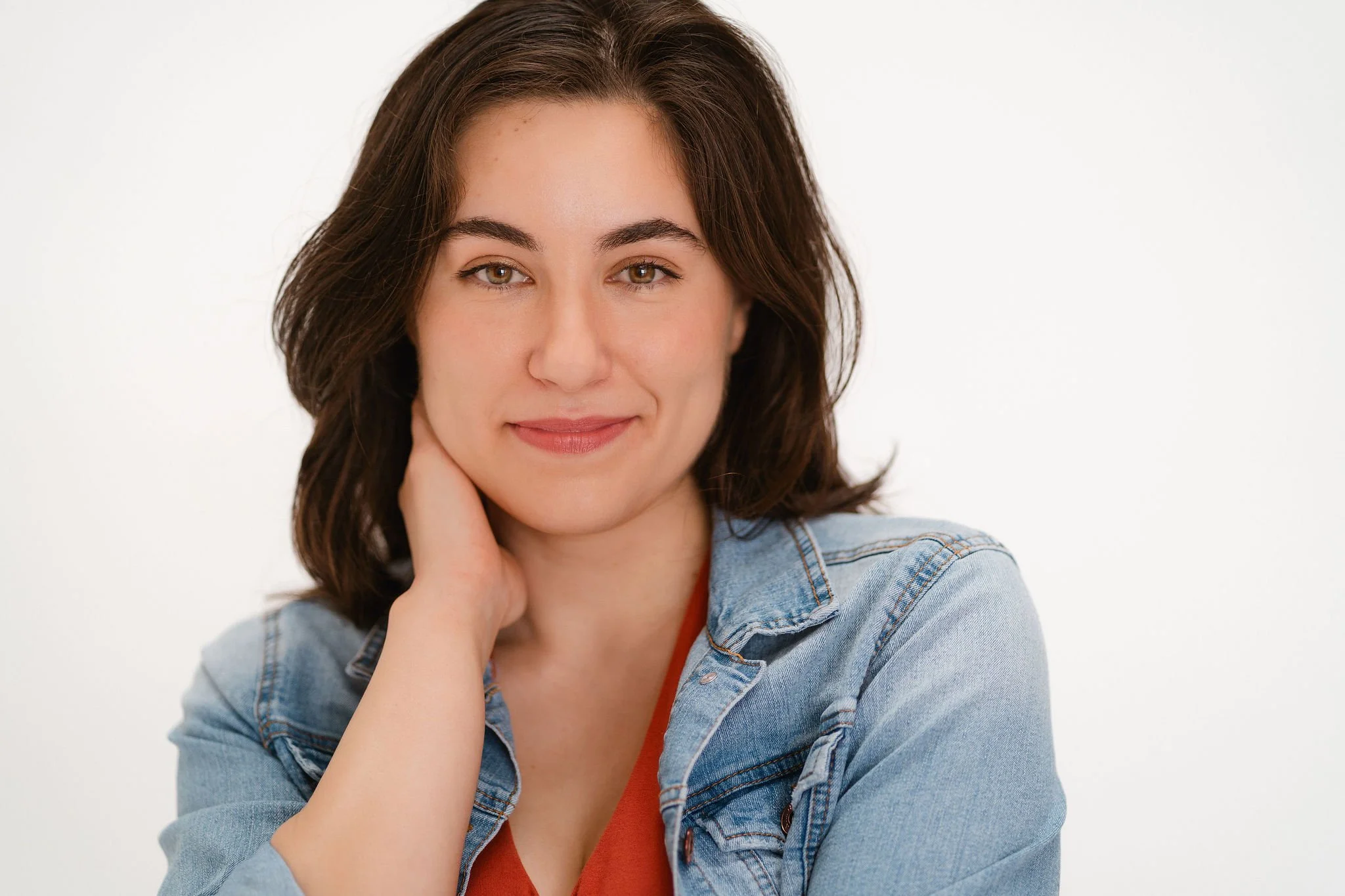 Monauar smiles while her hand covers her cheek