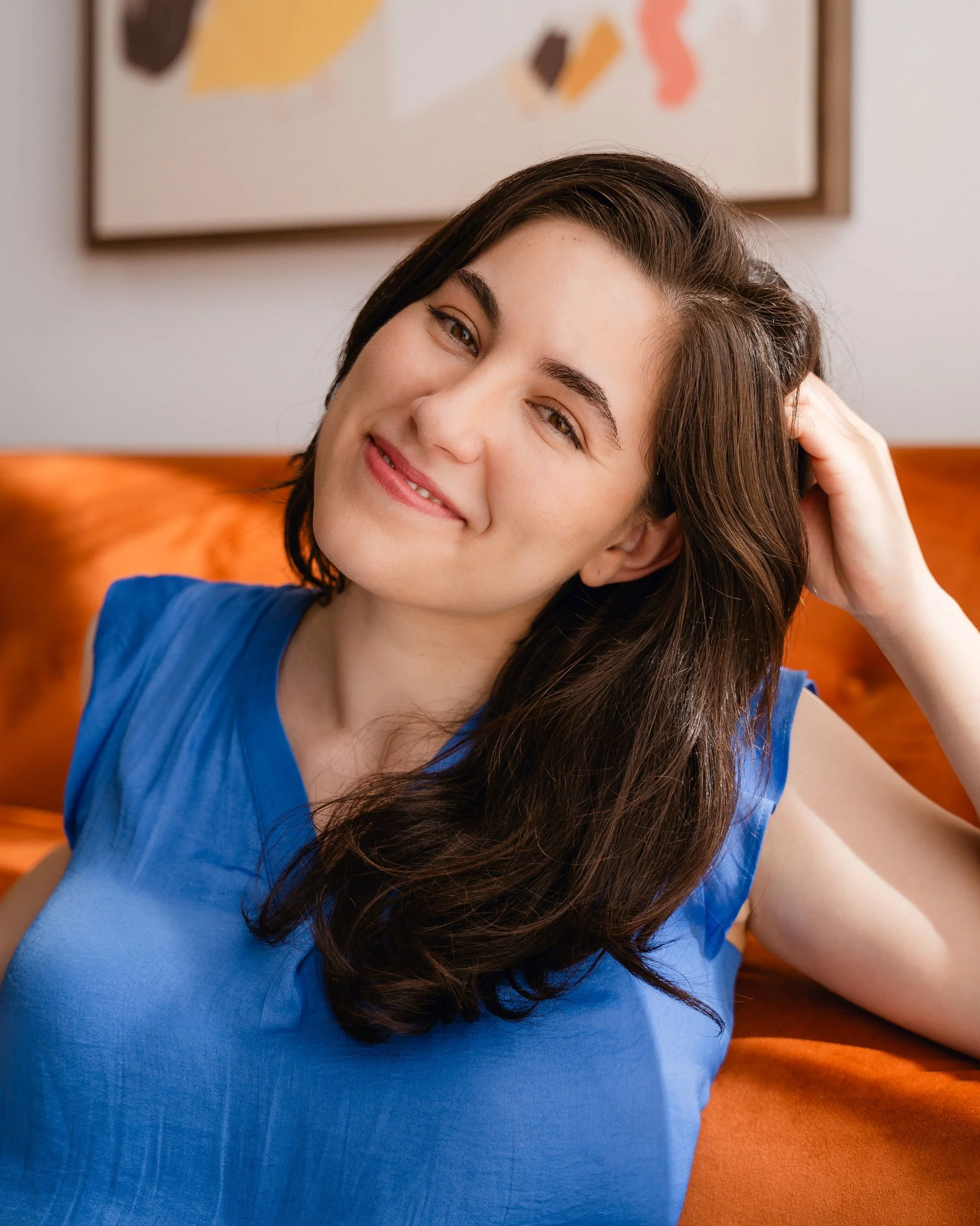 Monauar leaning on couch smiling at the camera