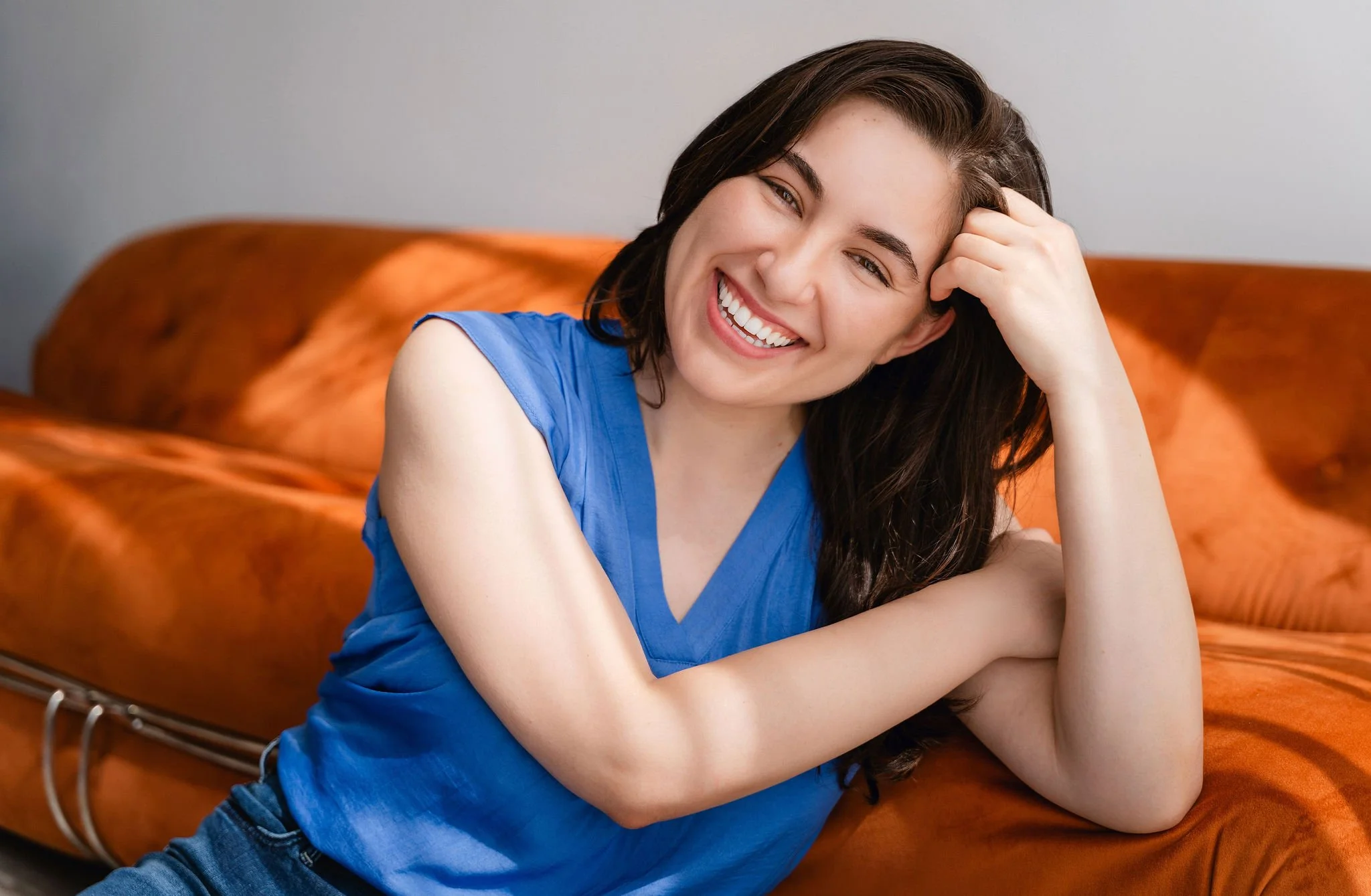 Monauar smiling while leaning on couch