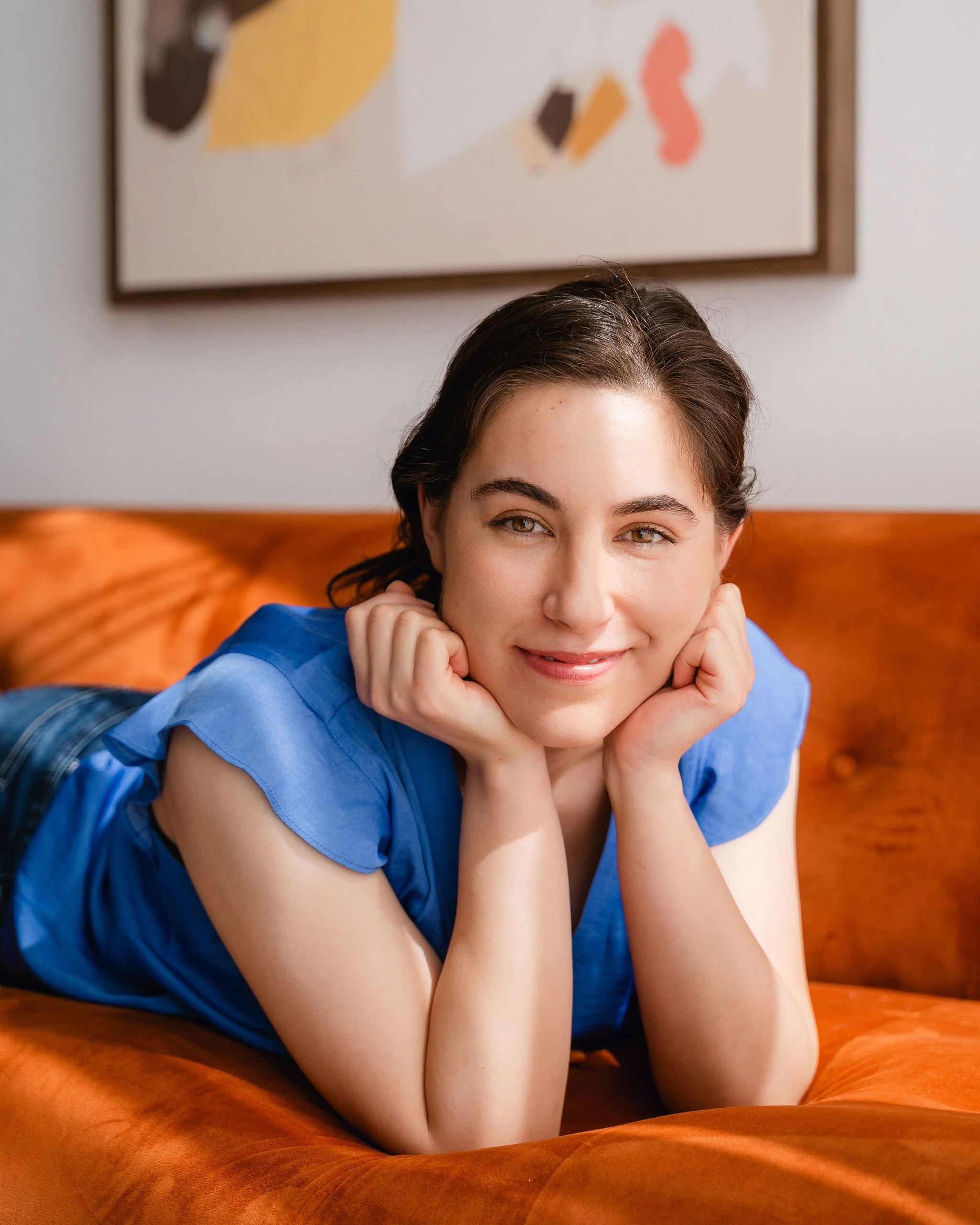 Monauar smiling with her head resting on her hands