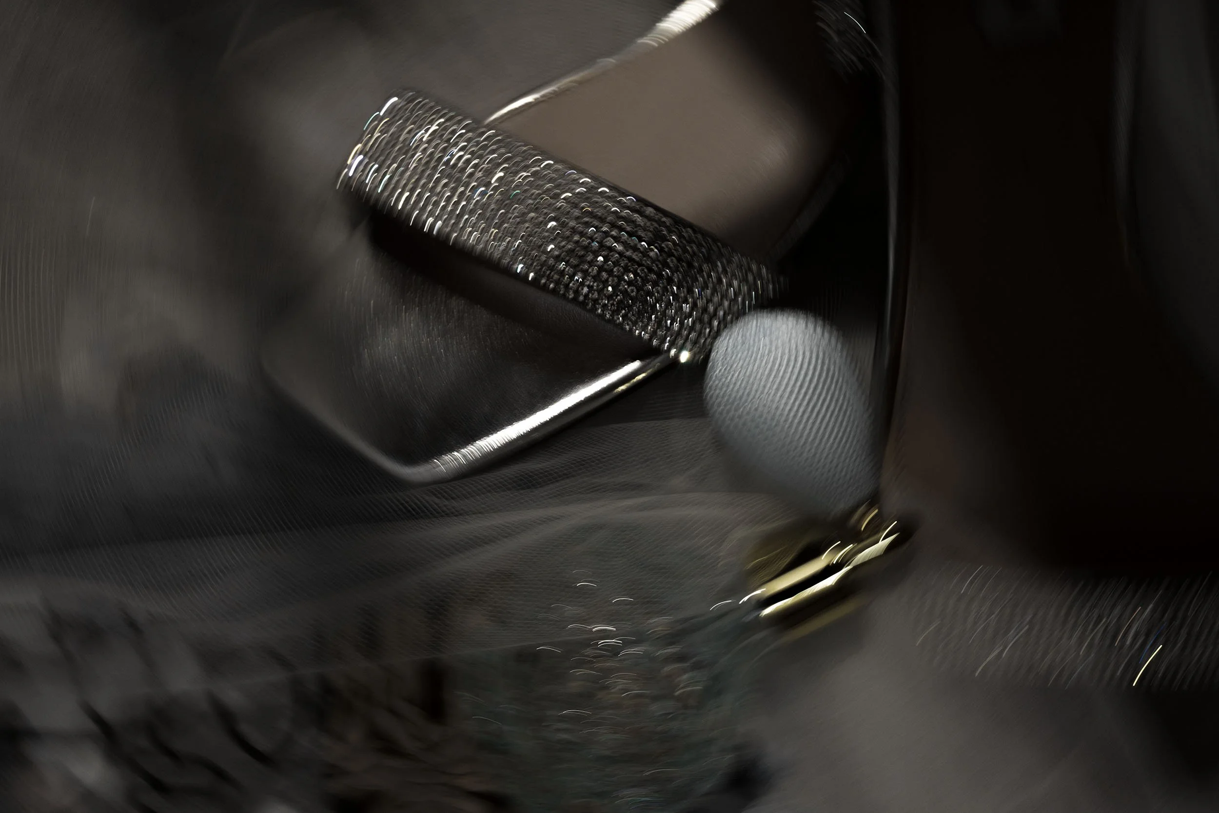 Detail shot of bridal shoes, a veil and a perfume bottle, photographed with motion blur for dramatic effect.
