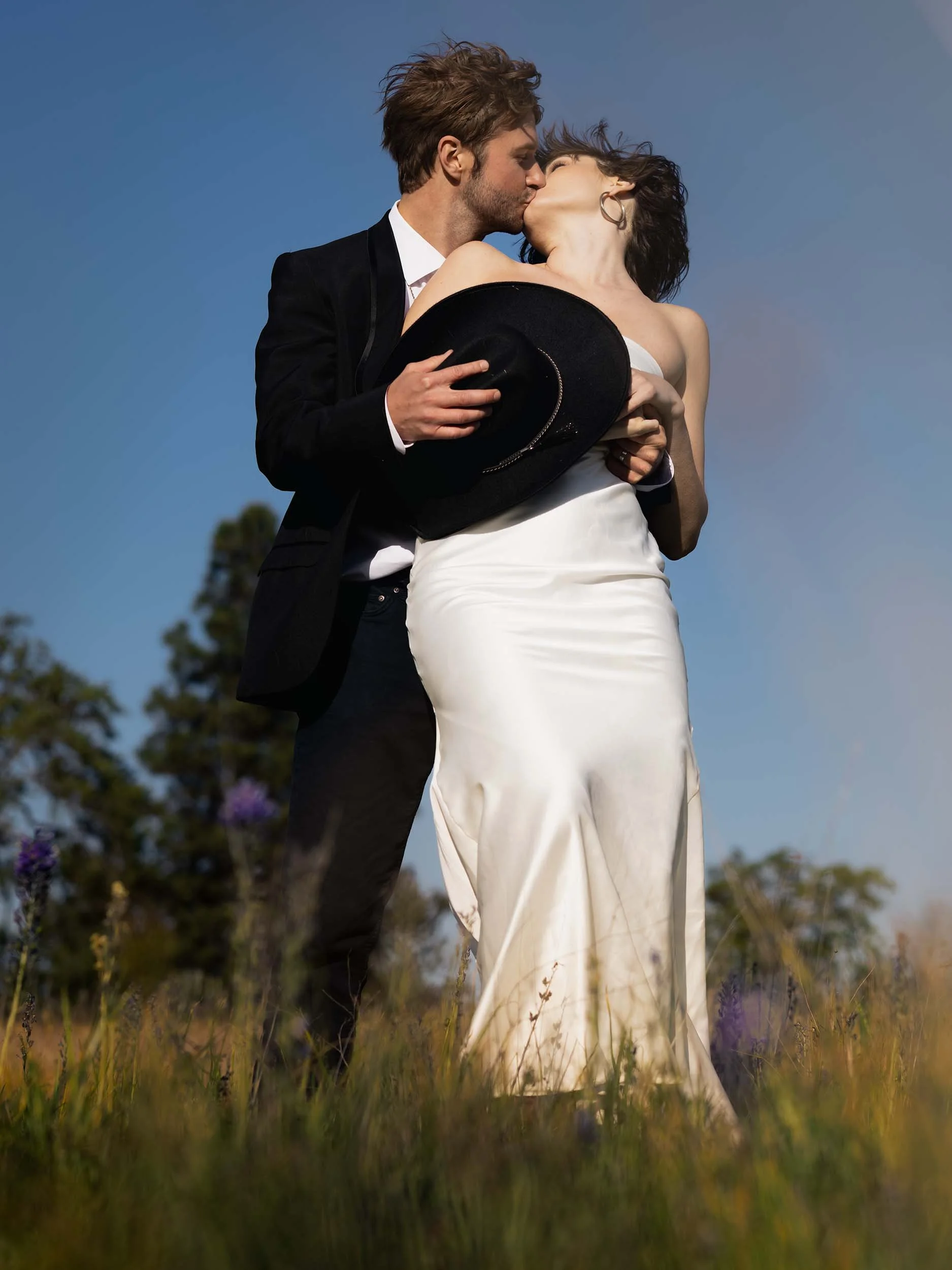 Western editorial couple kiss dramatically in a meadow of wildflowers overlooking the Columbia River Gorge during a summer elopement