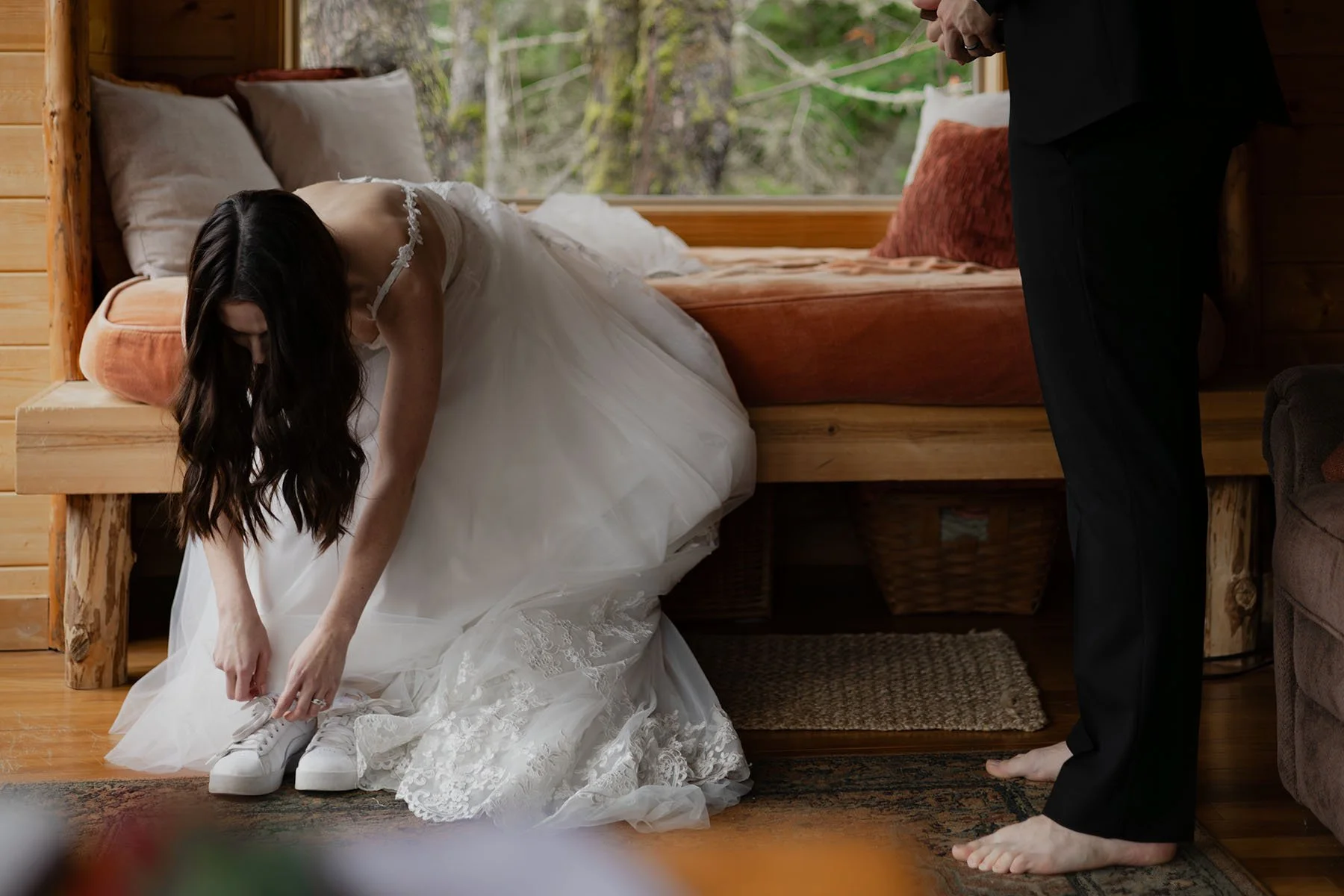 A bride and groom put on shoes and adjust clothing in preparation for their wedding day in Olympic National Park