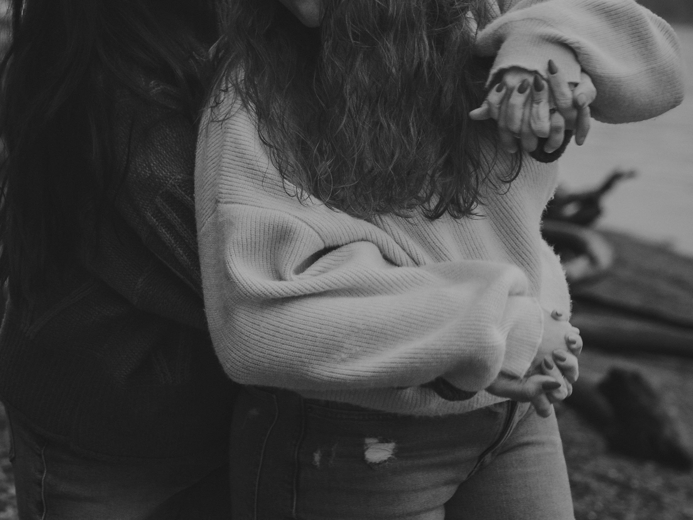LGBTQ couple interlace fingers at an Owen Beach engagement session in Tacoma.