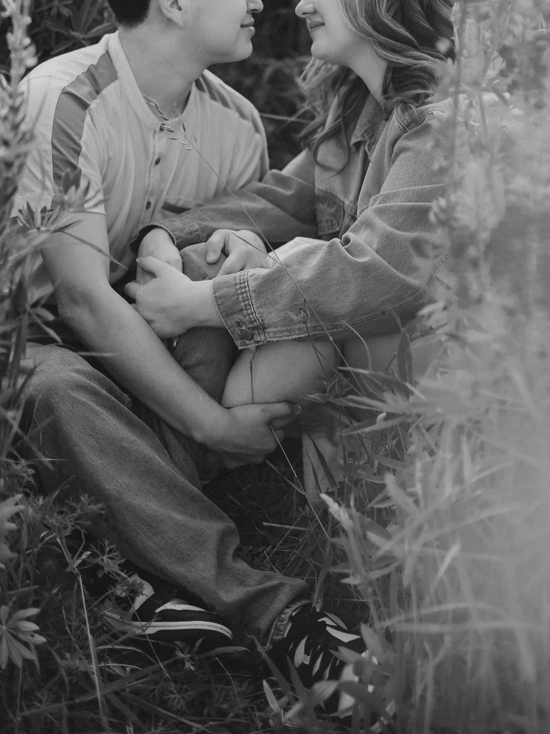 A couple intertwined, sitting in a flower field in Puyallup for their engagement session.
