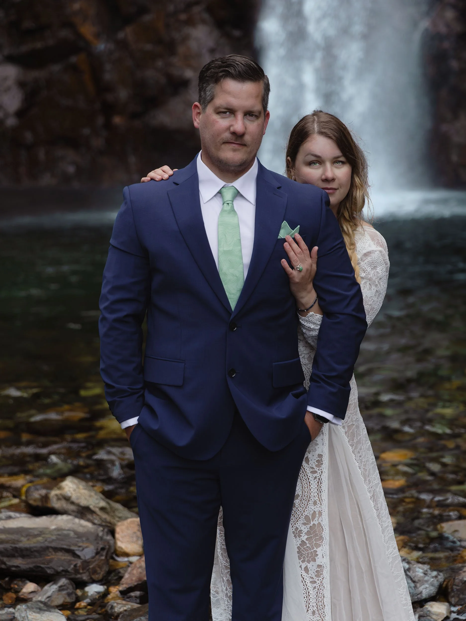 Bride and groom pose for a portrait in front of Franklin Falls during their elopement.