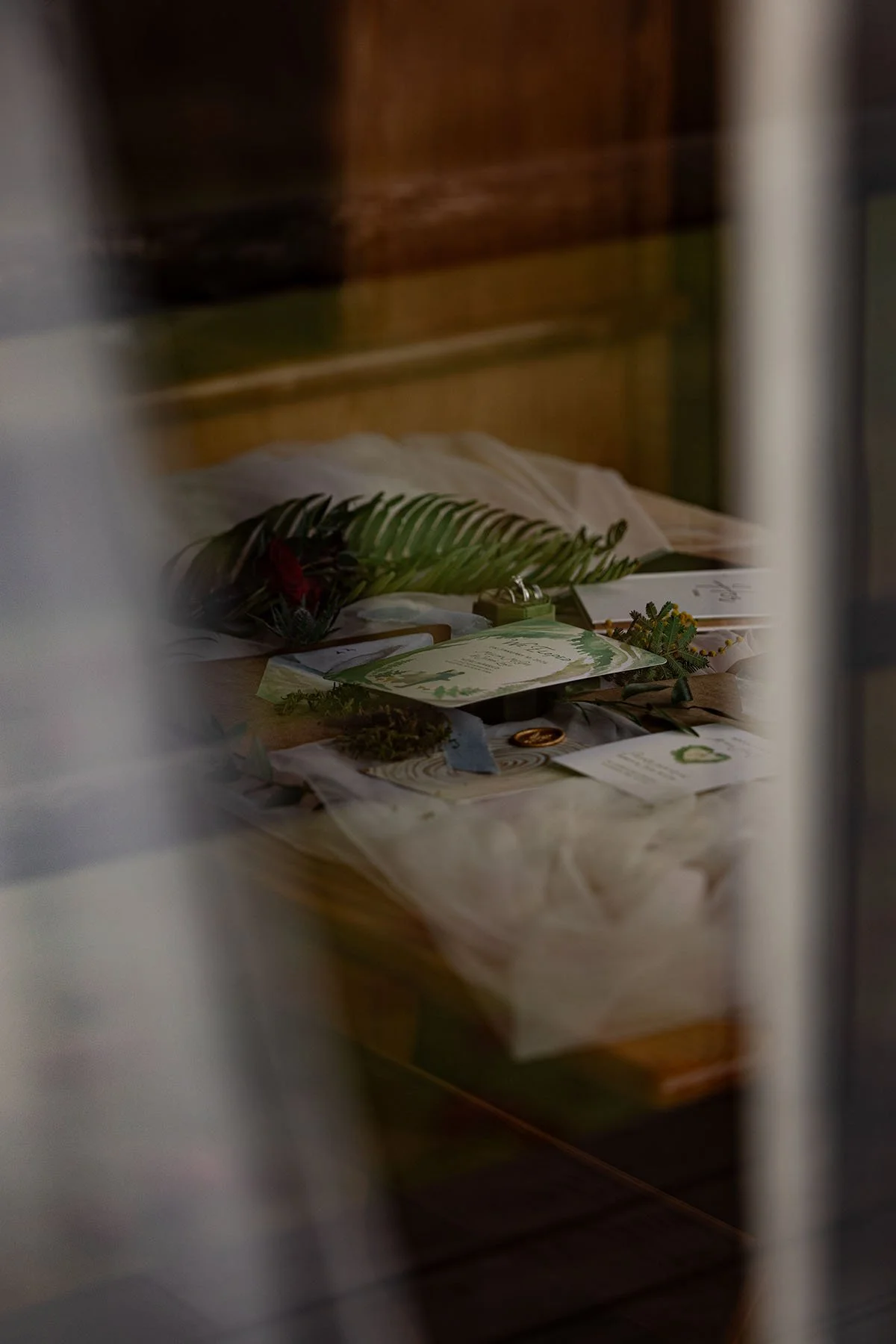 An assortment of wedding flat lay items as viewed from outside through a window