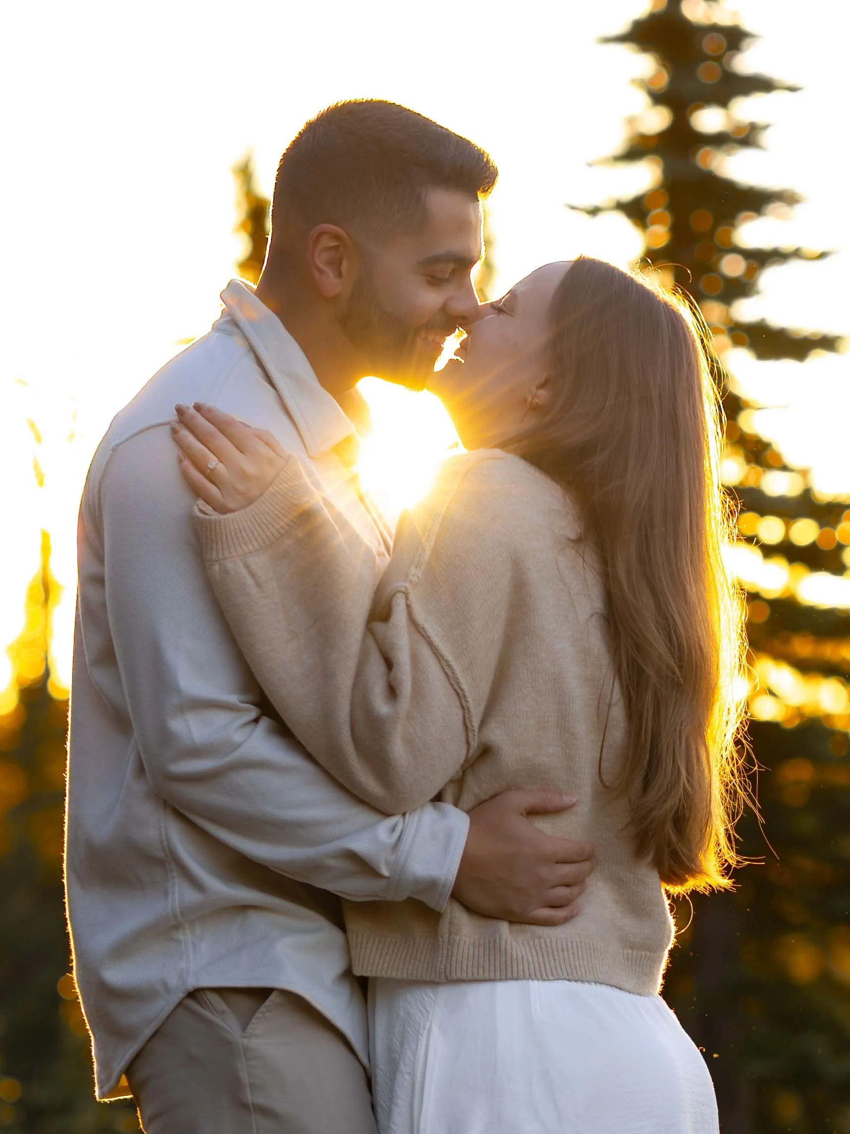 The sunrise shines between a smiling couple at their Mount Rainier engagement session.