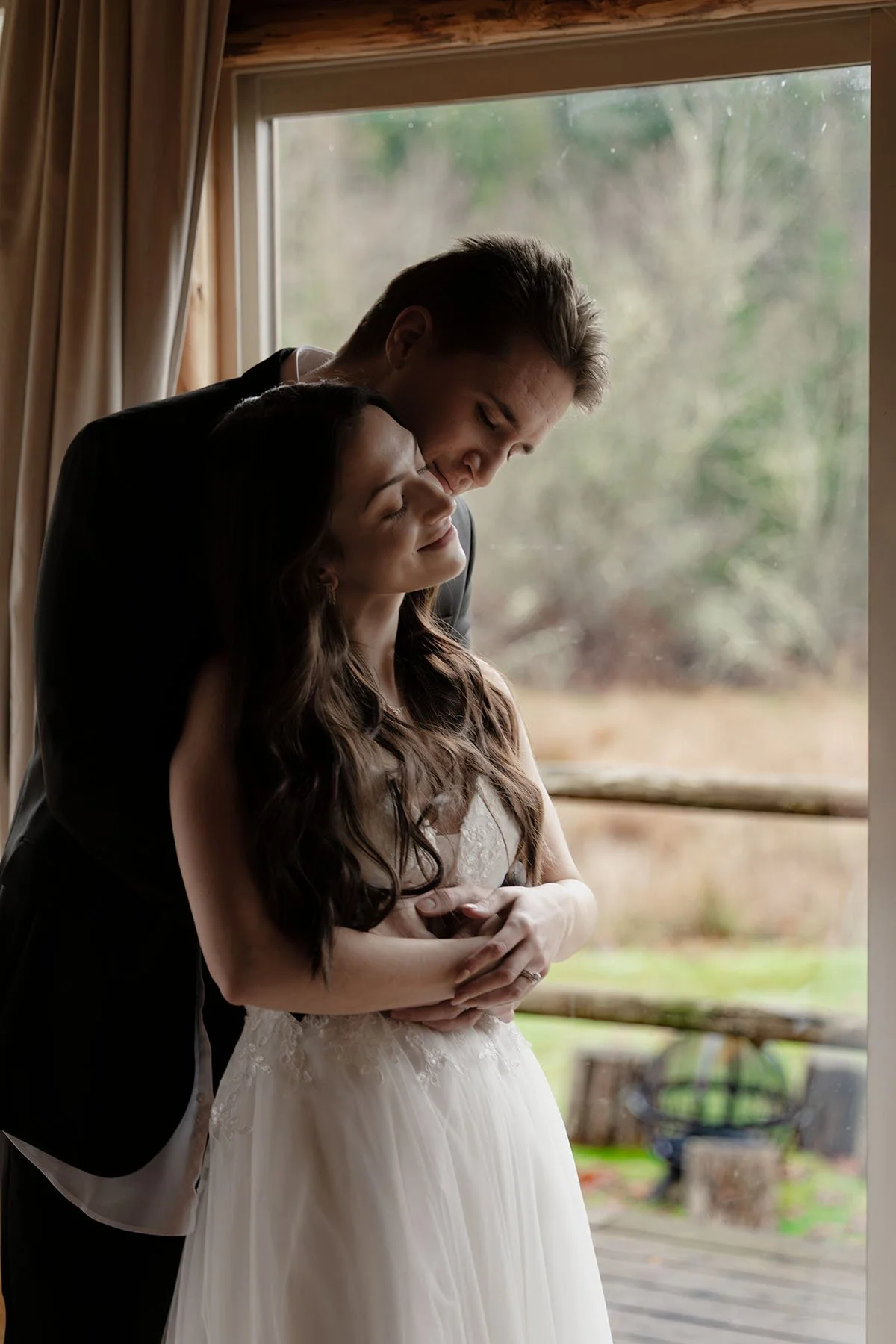 A couple in wedding attire embrace while getting dressed on the morning of their Olympic National Park elopement