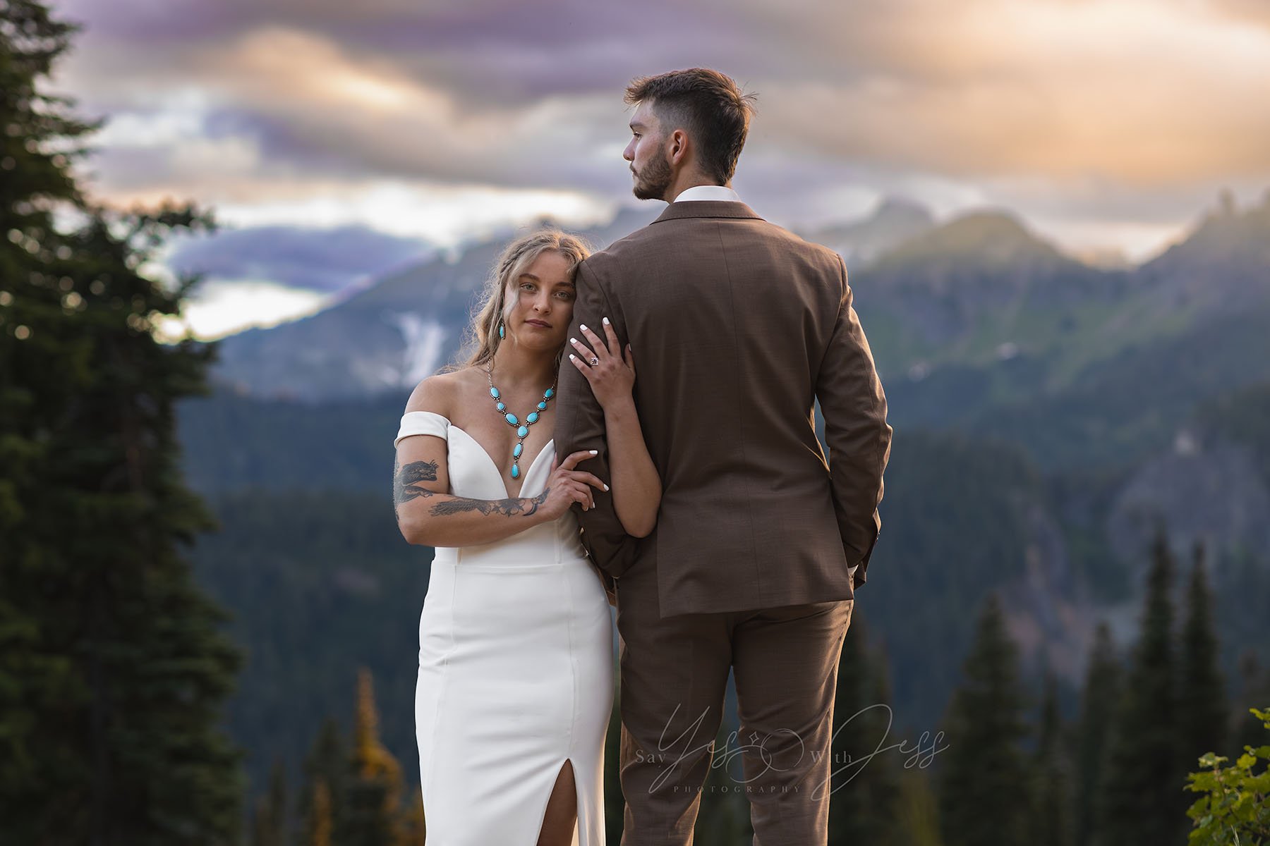A bride and groom pose at sunset at their elopement with a backdrop of Mount Rainier.