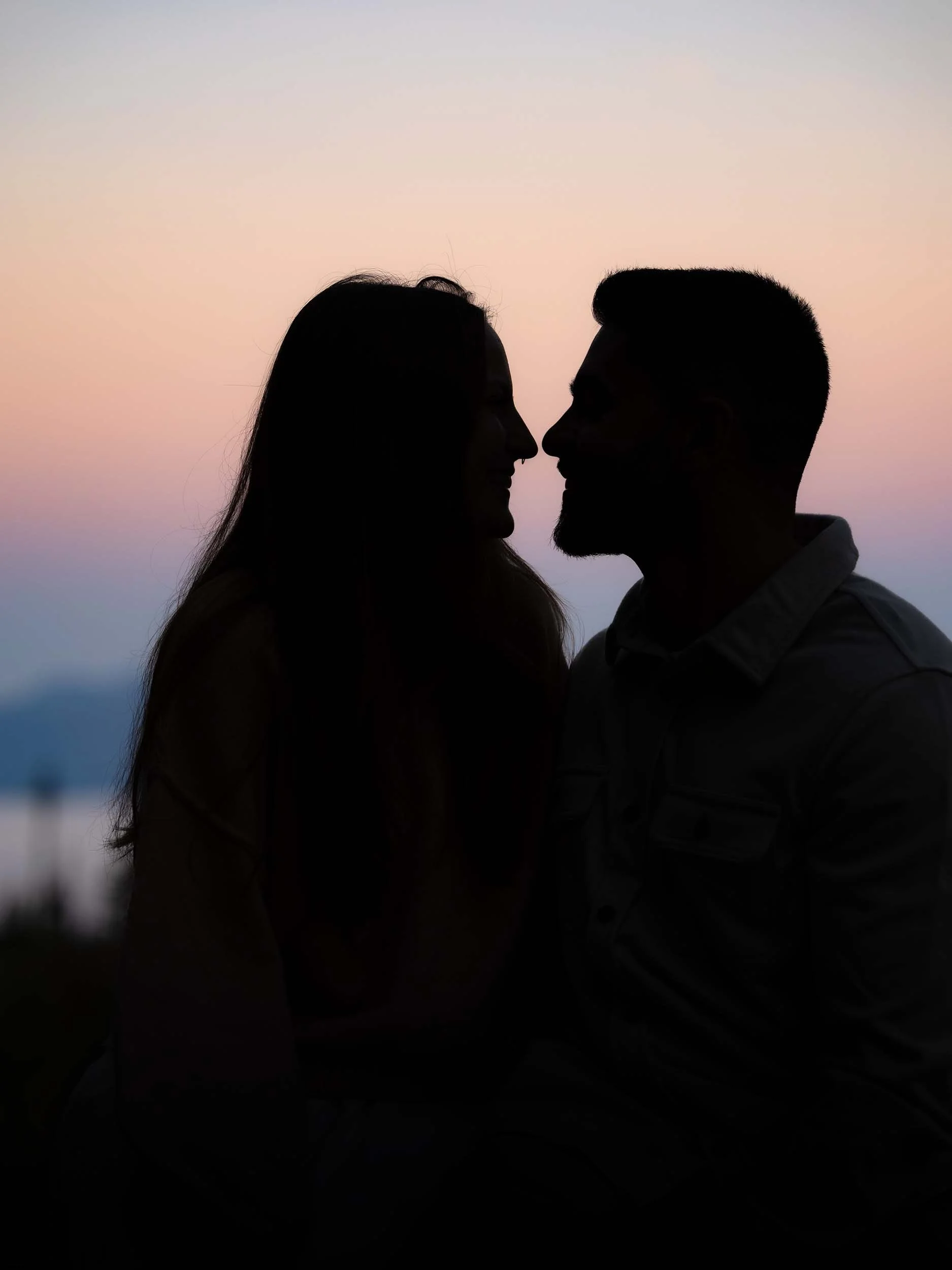 Shadow outline of a smiling couple at Mount Rainier with a cotton candy colored sunrise.