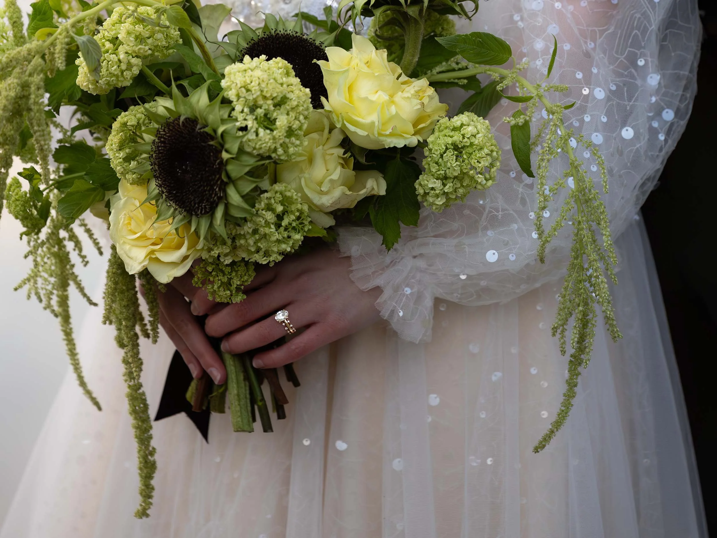 Bridal details crop showing the bouquet and wedding rings. She wears a sparkly blush gown at her Sultan, WA elopement.