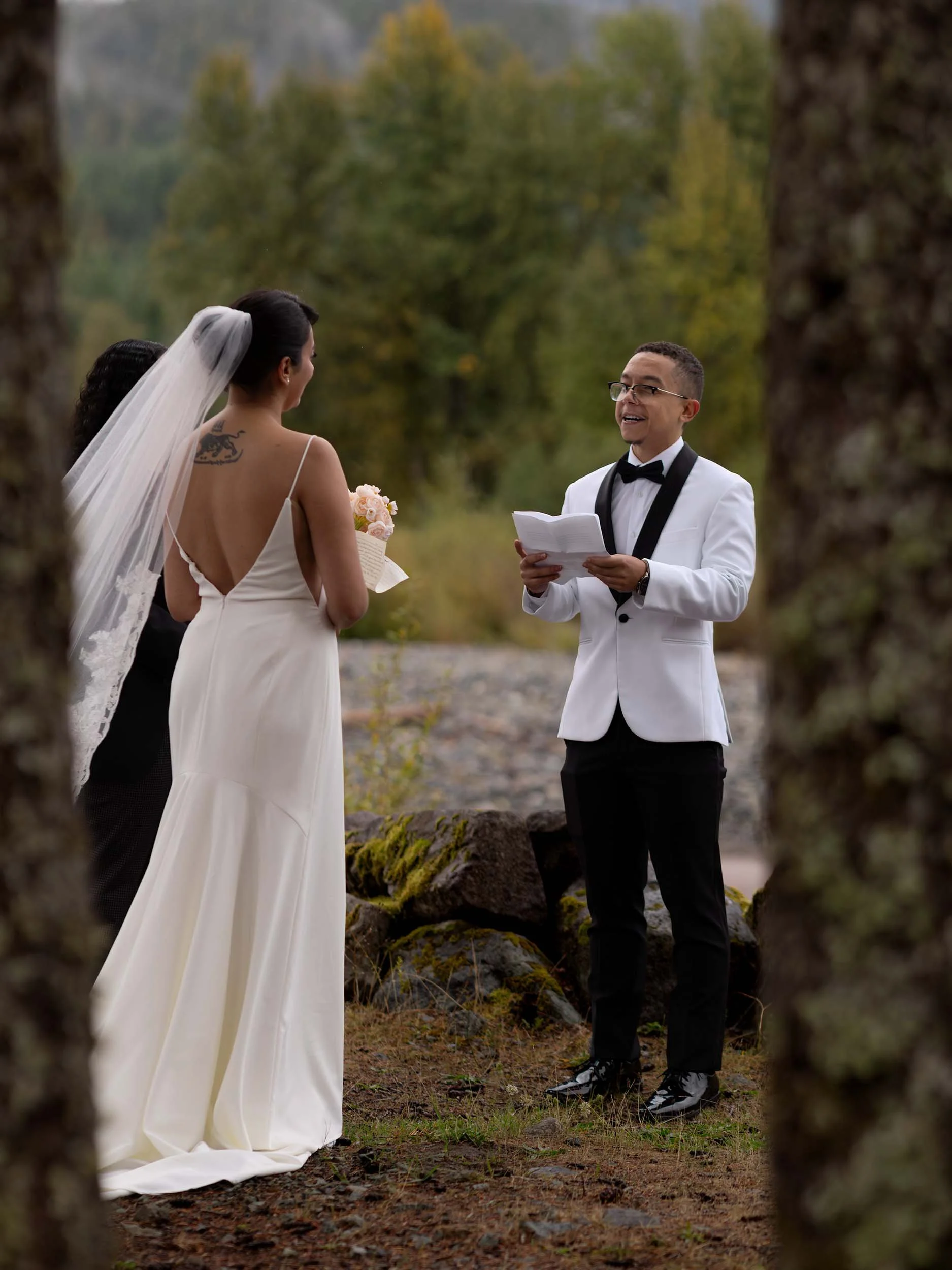 A groom reads his vows during a micro wedding ceremony on the Nisqually River near Mount Rainier