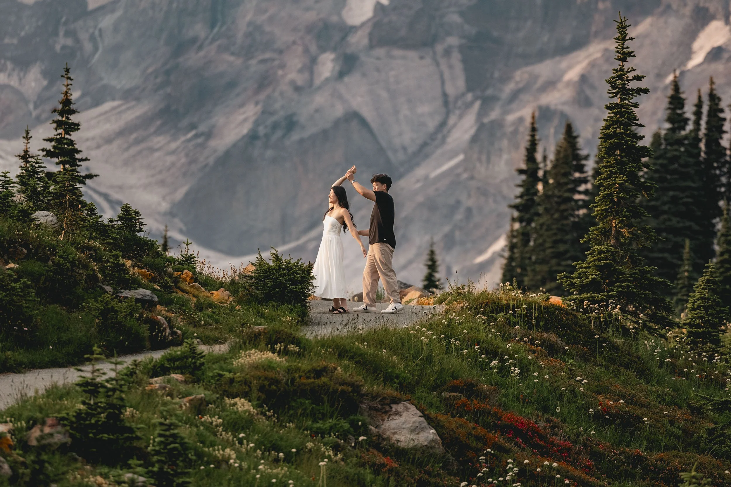 A couple dance during their wildflower engagement session at Mount Rainier.