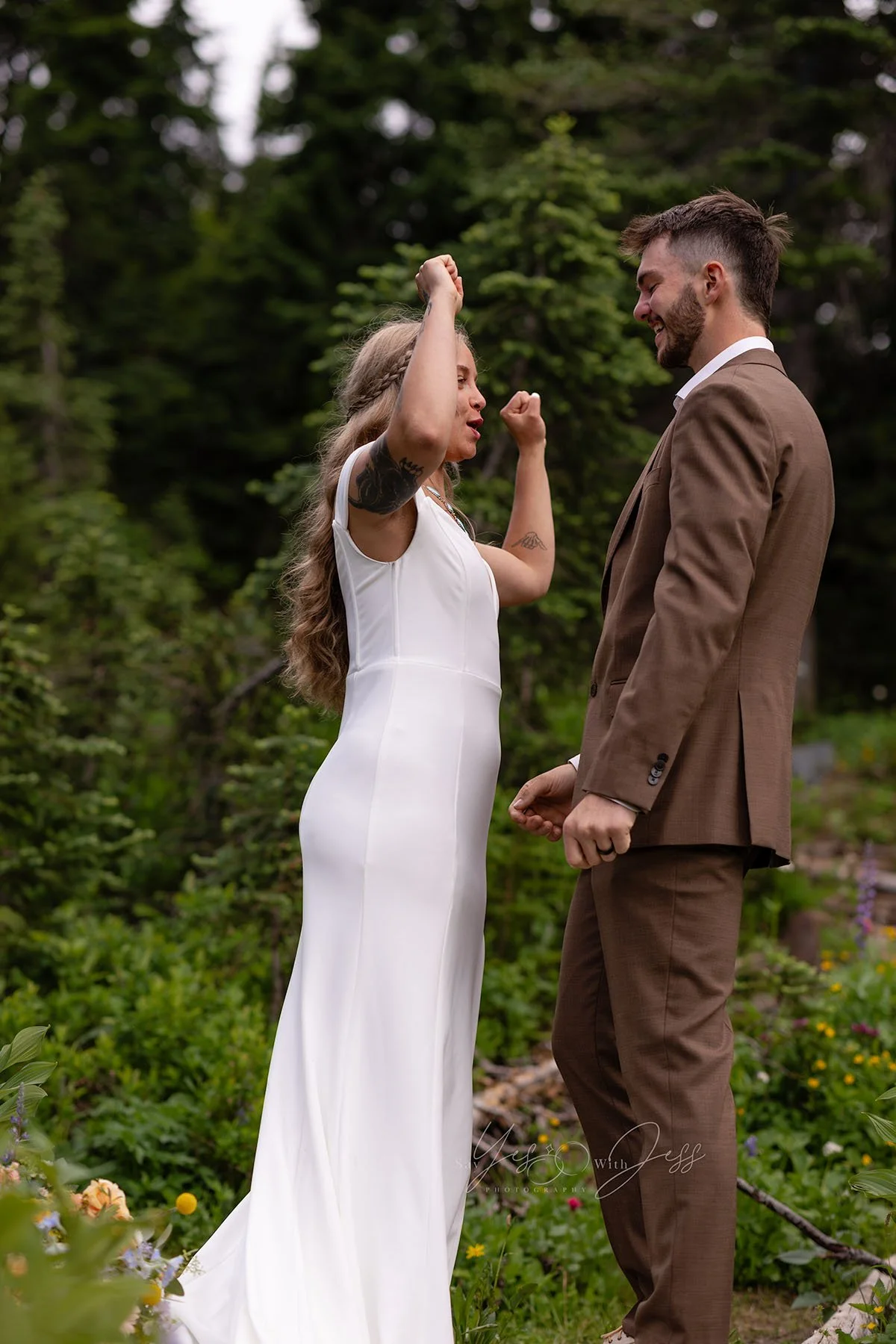 The bride and groom cheer after their elopement ceremony at Tipsoo Lake during wildflower season.