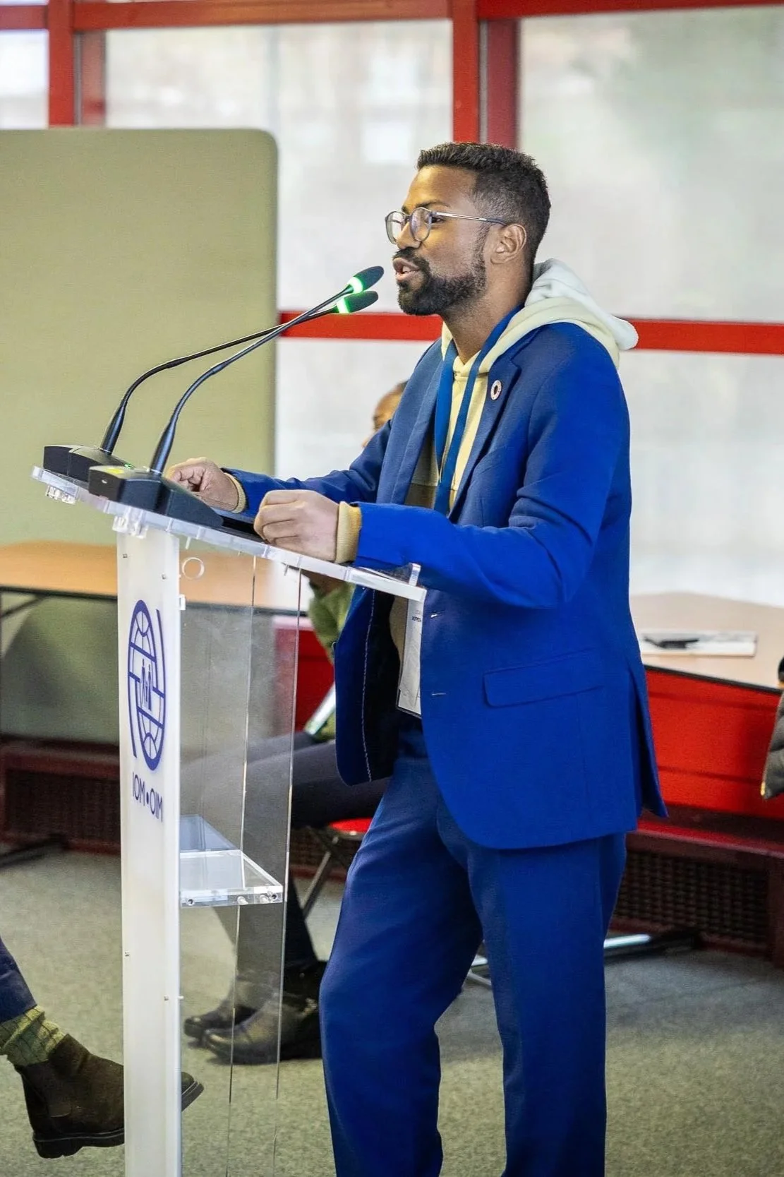 Florencio, a man with glasses and a beard speaking at a podium during a conference or meeting.