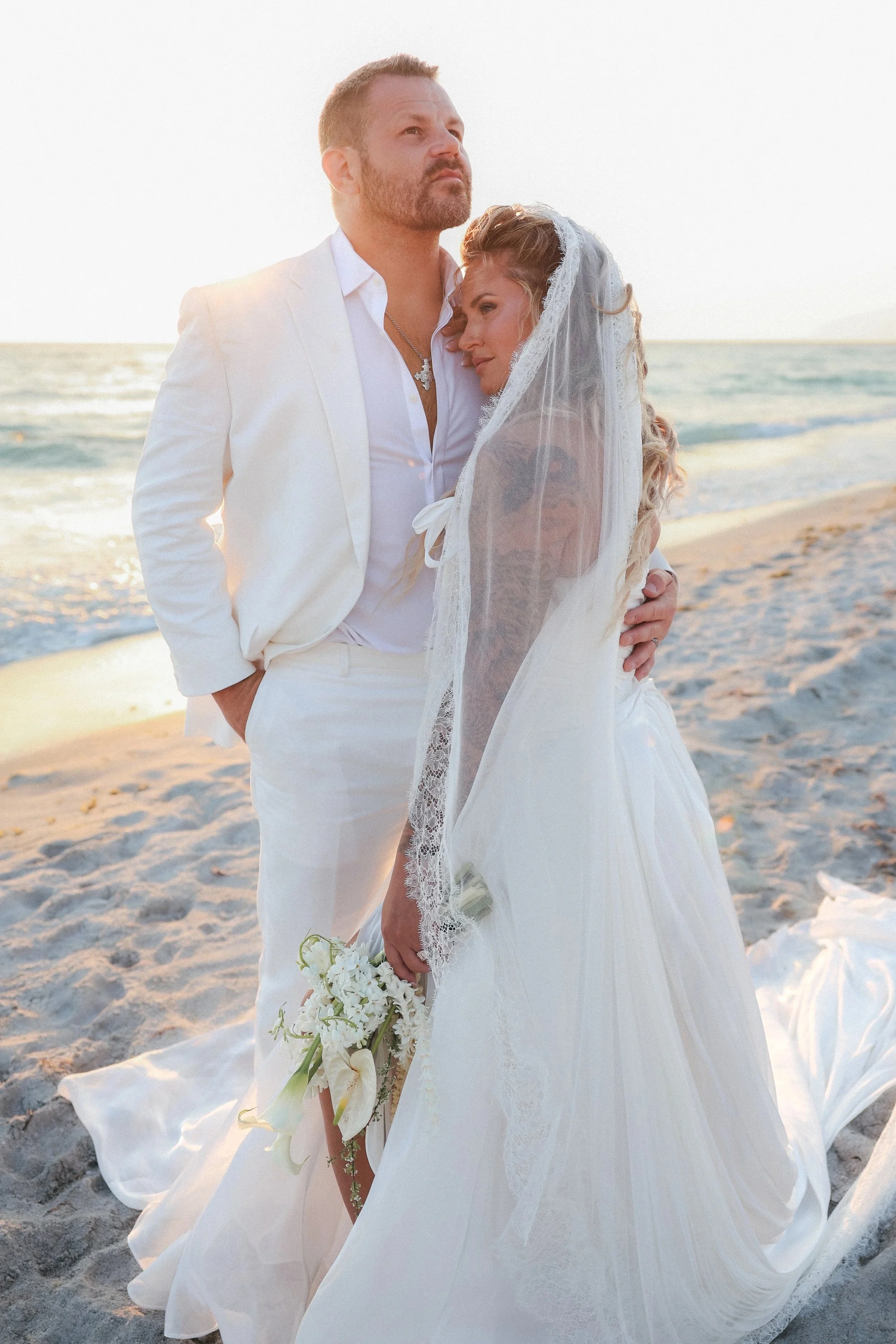 Bride and groom embracing on the beach at golden hour at the St. Regis Longboat Key, photographed by Tampa Bay luxury wedding photographer Kristen Felicia of Divine Design Photography