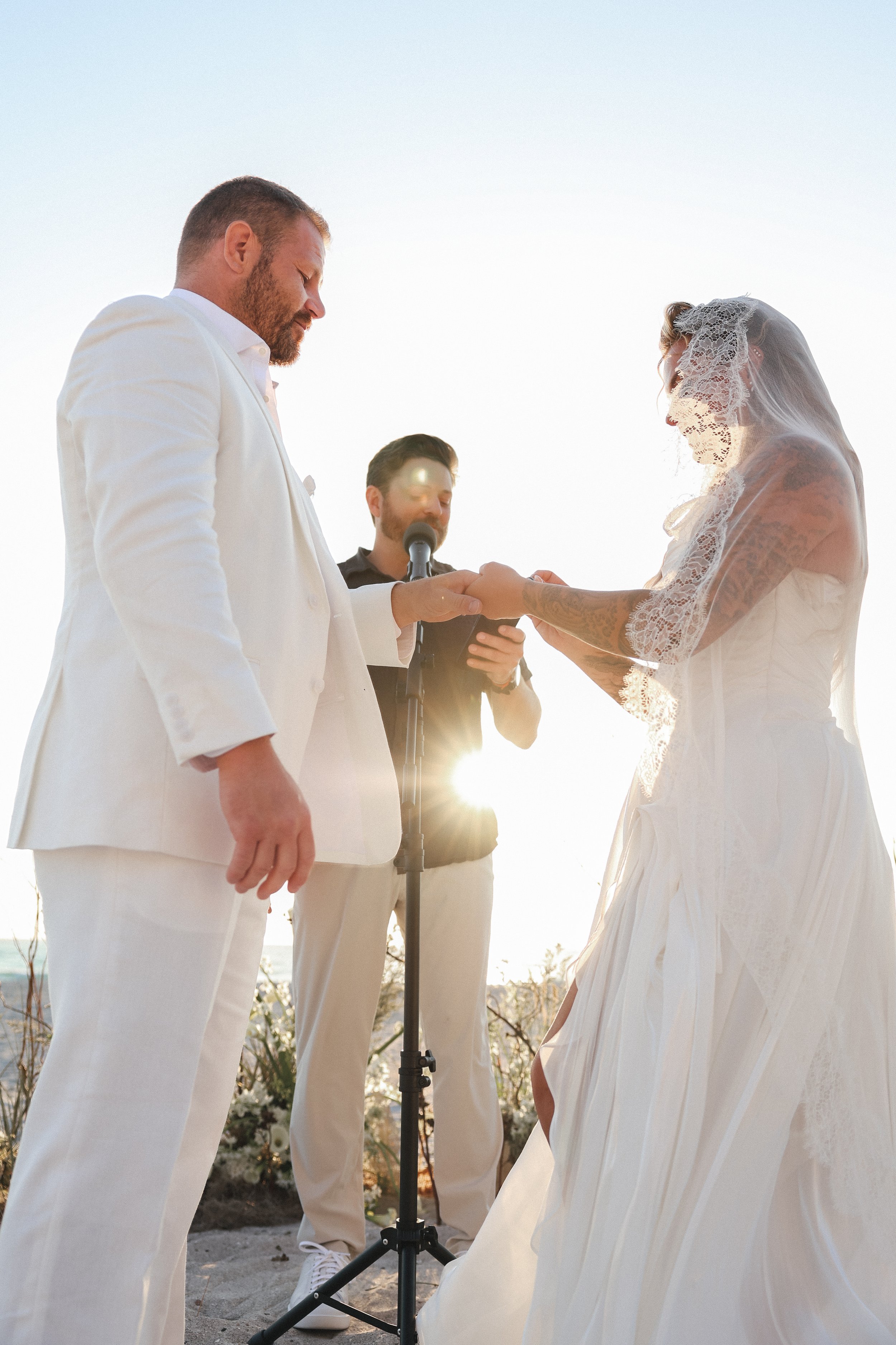 Bride placing ring on groom's finger during wedding ceremony at the St. Regis Longboat Key, Tampa Bay luxury wedding photographer Divine Design Photography