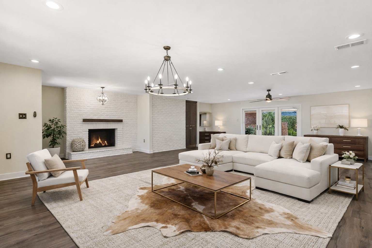 Luxury Listing pictures with Aimee (Amay) Curole, Top Realtor in Metairie, 23 Realty.  Living room with white sectional sofa, armchair, fireplace, ceiling fan, and large windows.