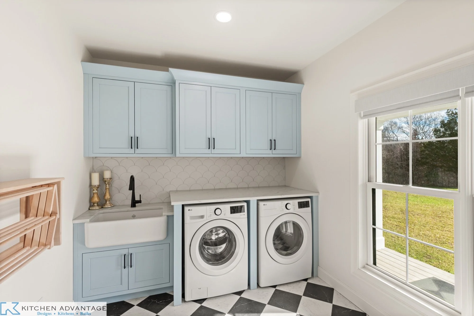Blue laundry room cabinetry with a sink and washer-dryer workspace