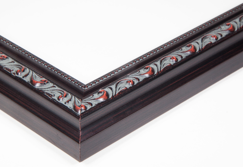 Close-up of a decorative picture frame with intricate detailing and dark wood finish.