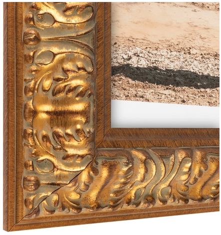 Close-up of an ornate gold and wood picture frame with intricate carvings.