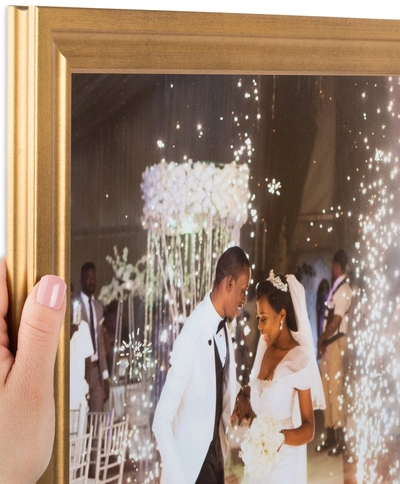 A newlywed couple sharing a dance at their wedding reception, with sparklers and guests in the background.