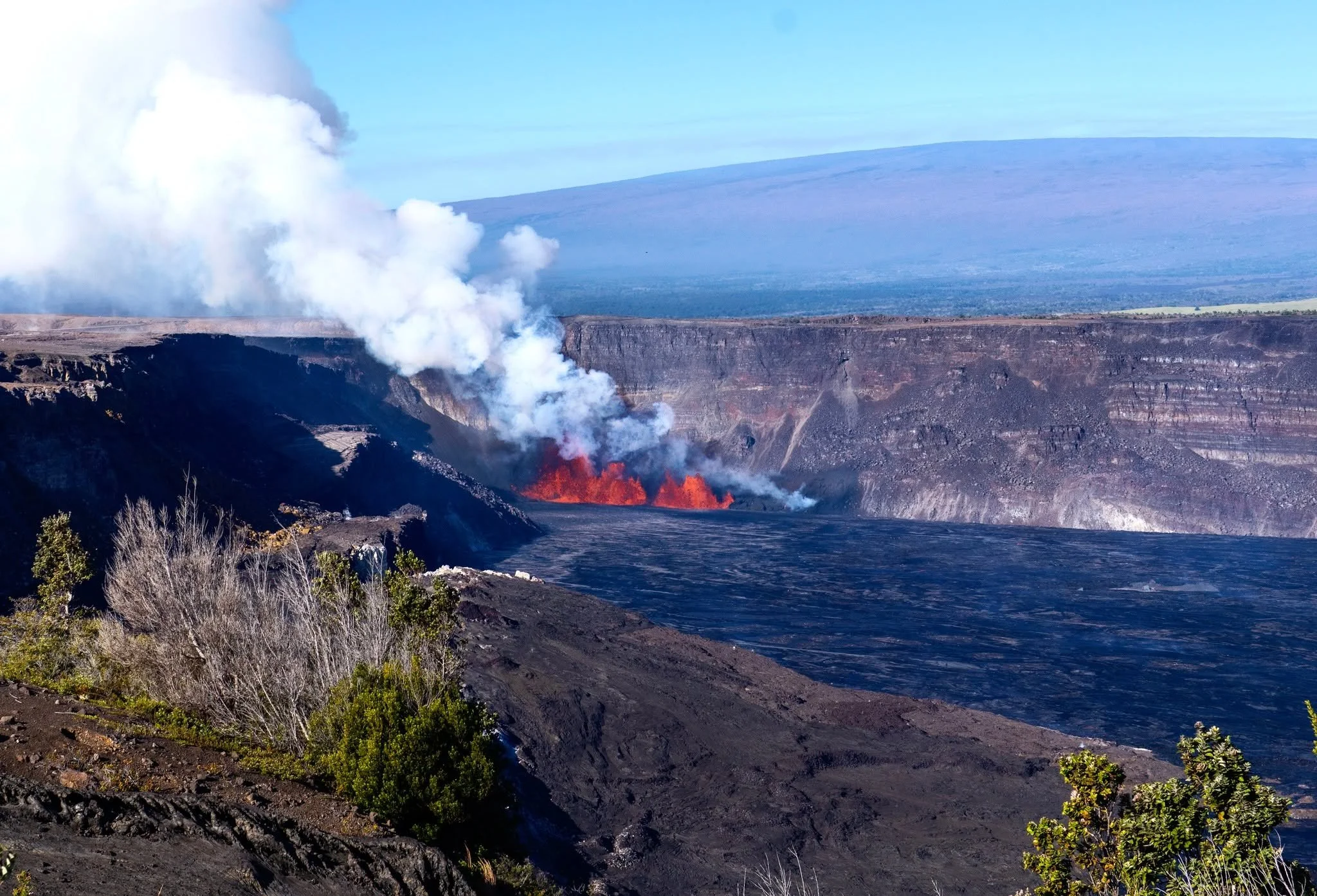 BEFORE ➡️ AFTER. Same crater. 15 months apart. 🌋

Image 1: December 23, 2024 &mdash; Episode 1 begins. Lava fountains erupt inside Halemaʻumaʻu for the first time in months.

Image 2: March 21, 2026 &mdash; After Episode 43. Look at that cinder cone