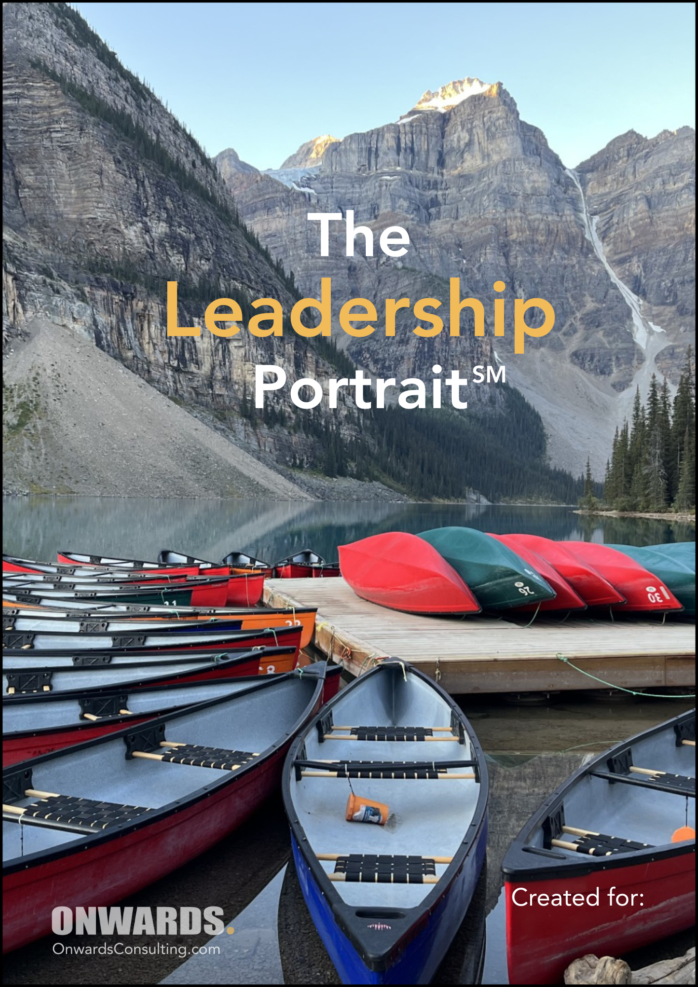 Several canoes and kayaks are docked on a wooden pier beside a lake, with mountainous terrain and trees in the background, under a clear sky.