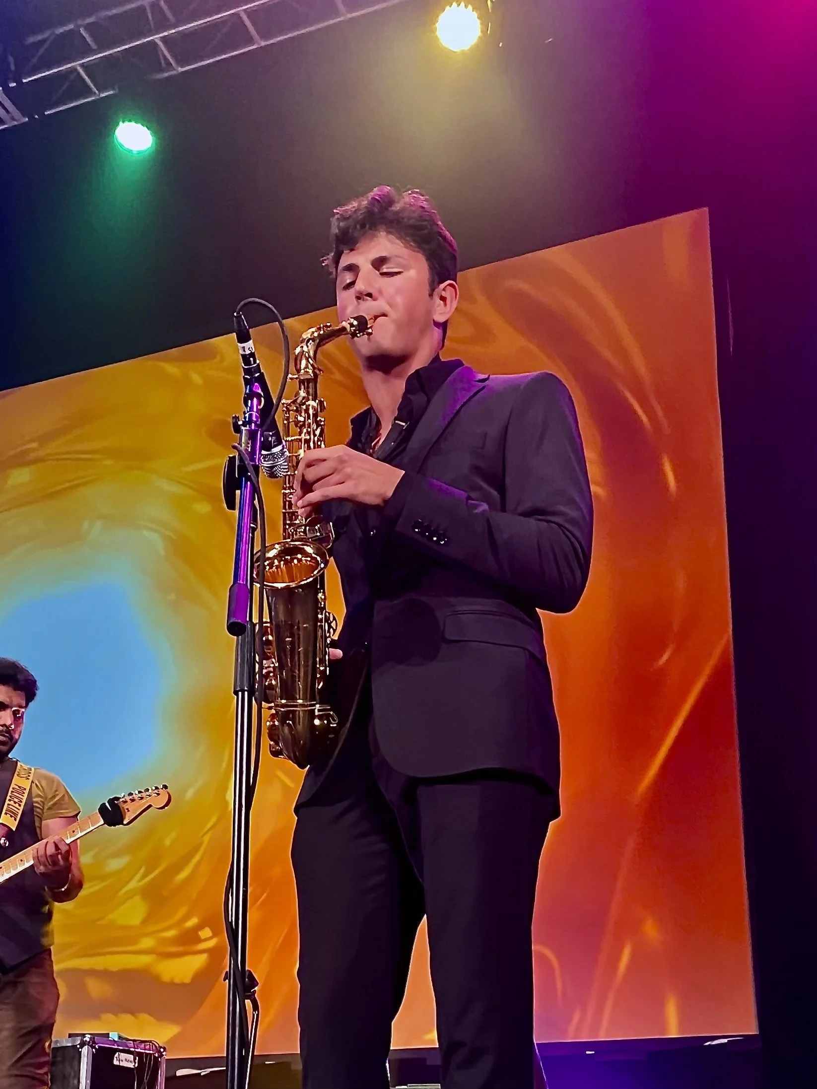 Saxophonist performing live on stage at an upscale event