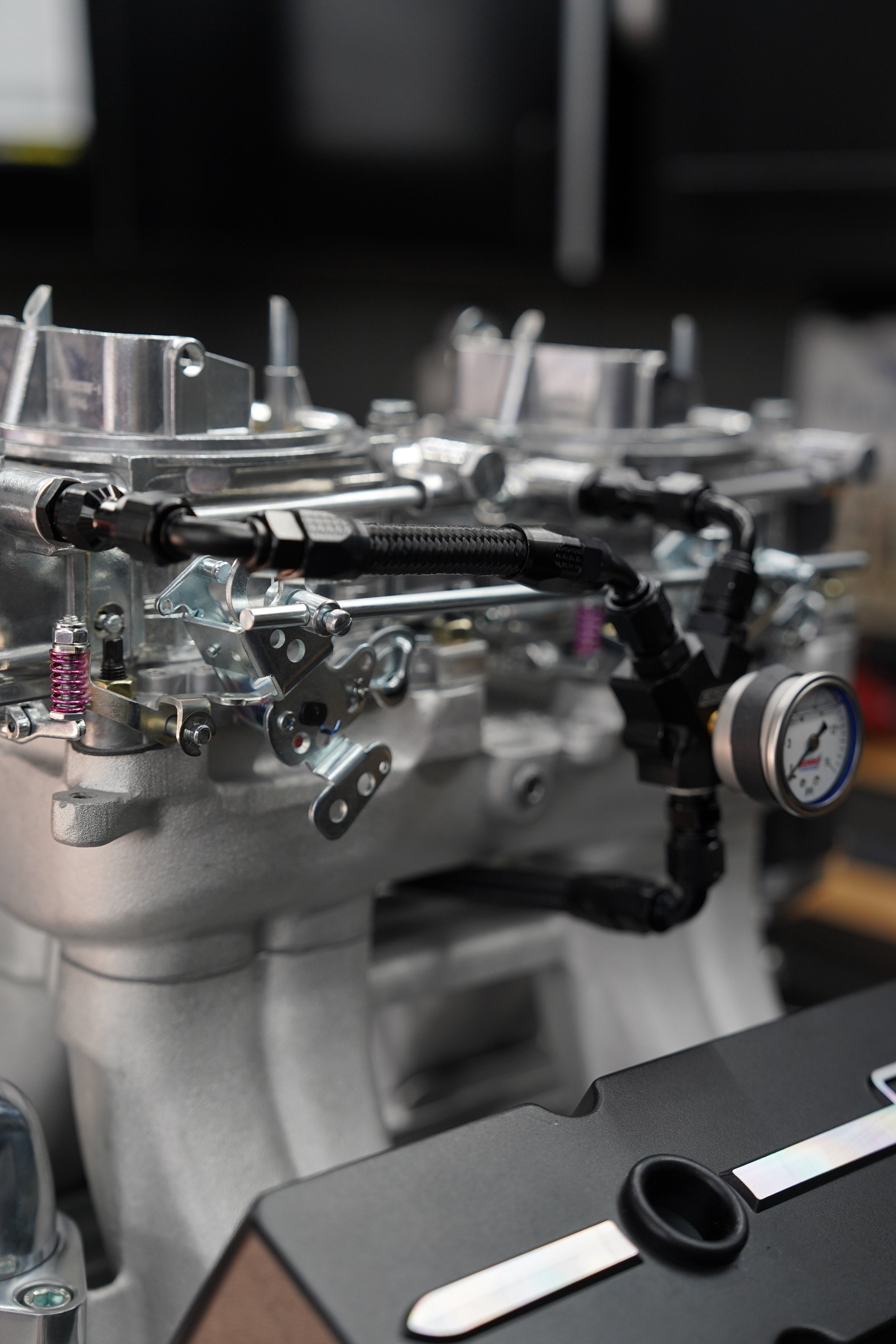 Close-up of mechanical components, pipes, and gauges on a metallic machine or engine.