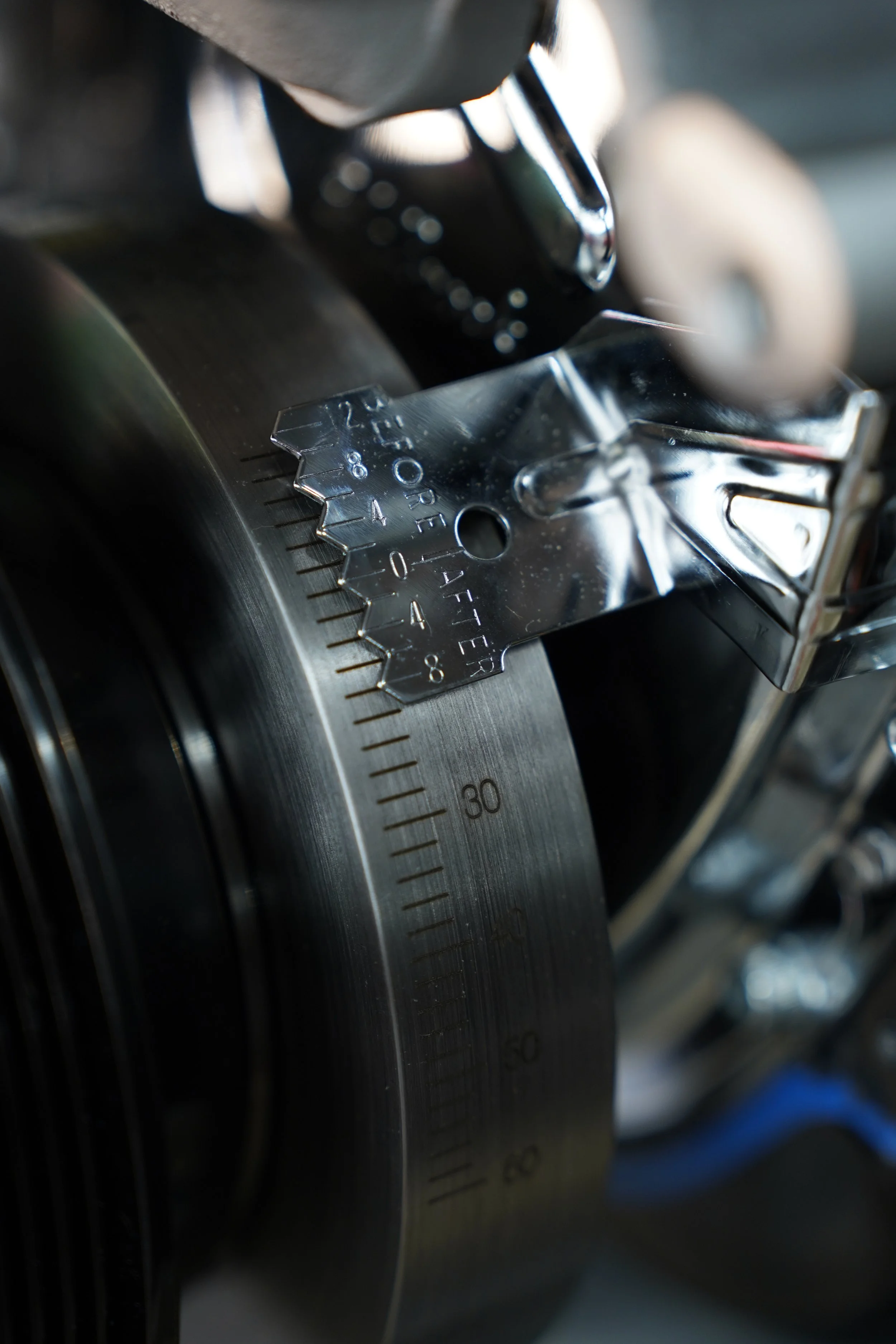 Close-up of a rotary mechanical timer or gauge with engraved measurement markings, attached to a metallic surface.