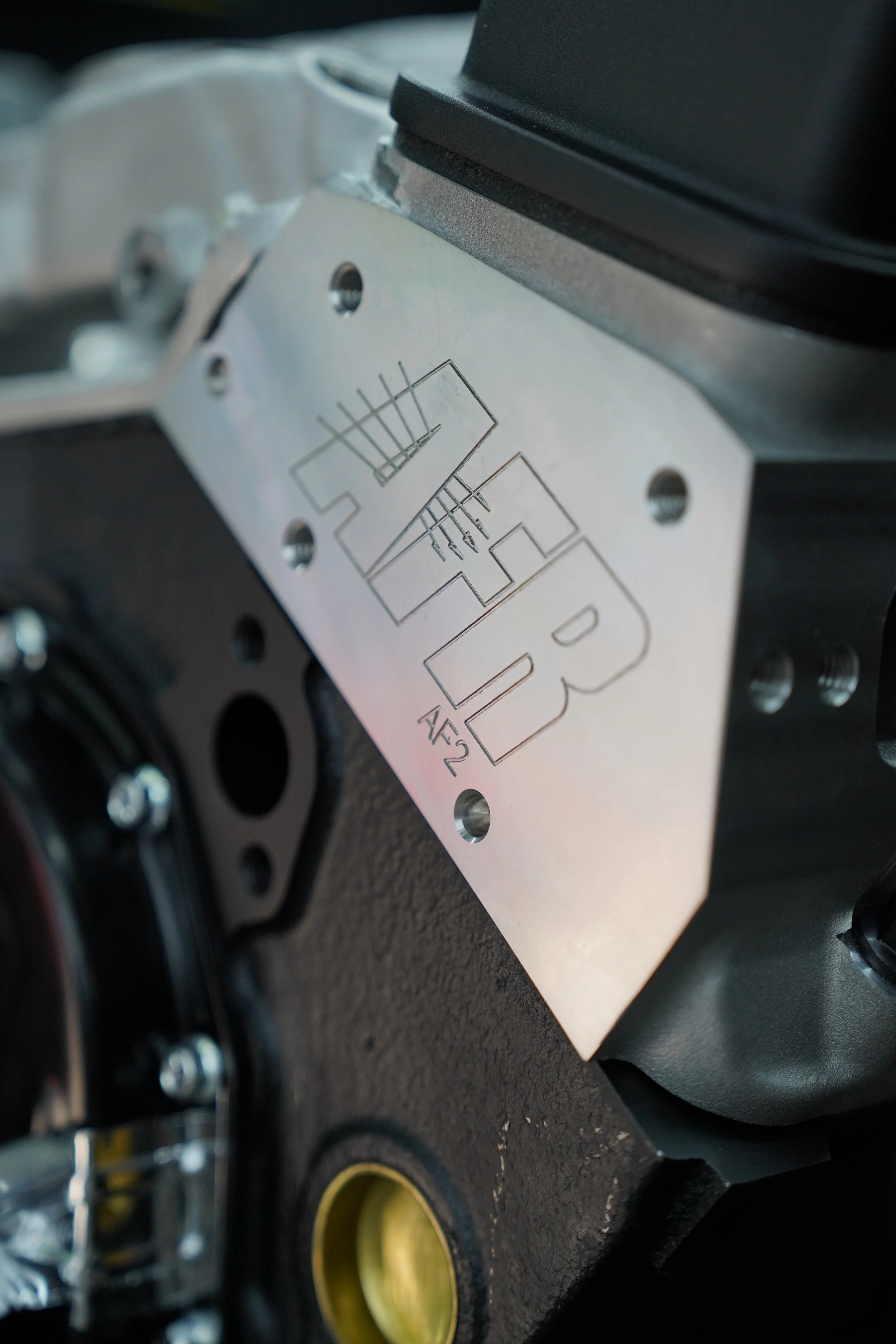 Close-up of a metal plate with engraved technical drawings and markings, attached to a mechanical or industrial component.