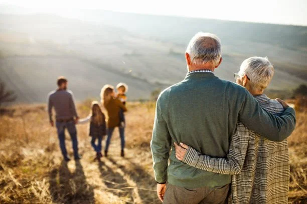 Three generations of family members, backs to camera