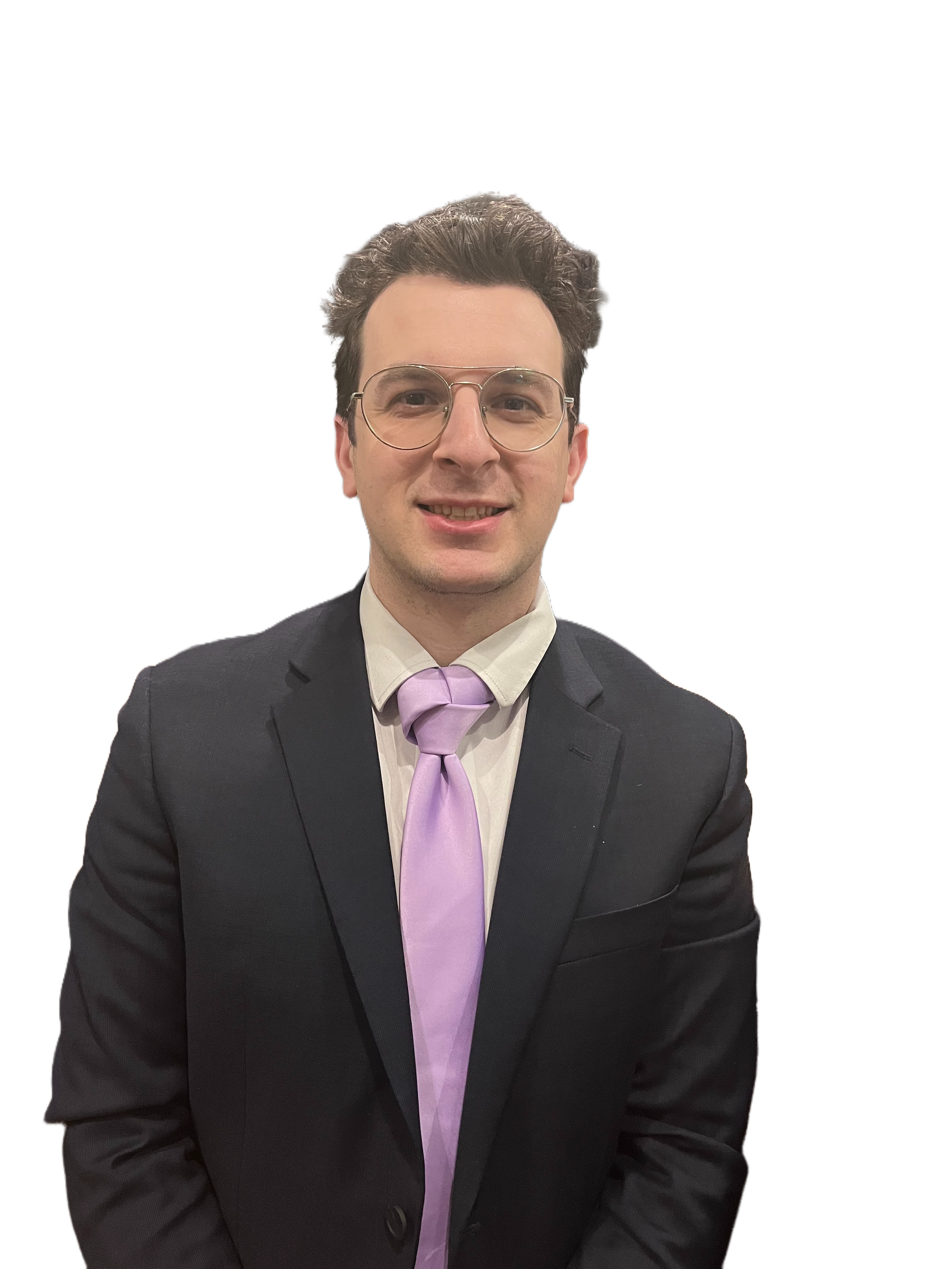 眼鏡をかけた男性が、黒いスーツと淡い紫色のネクタイを着用し、カメラに向かって微笑んでいる。