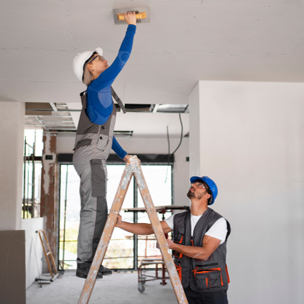 Equipo de trabajo realizando labores de remodelación en espacio interior, con personal utilizando casco y equipo de seguridad, enfocados en mejoras y mantenimiento estructural del inmueble.