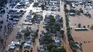 Aerial view of a parking lot and surrounding buildings submerged in floodwaters.