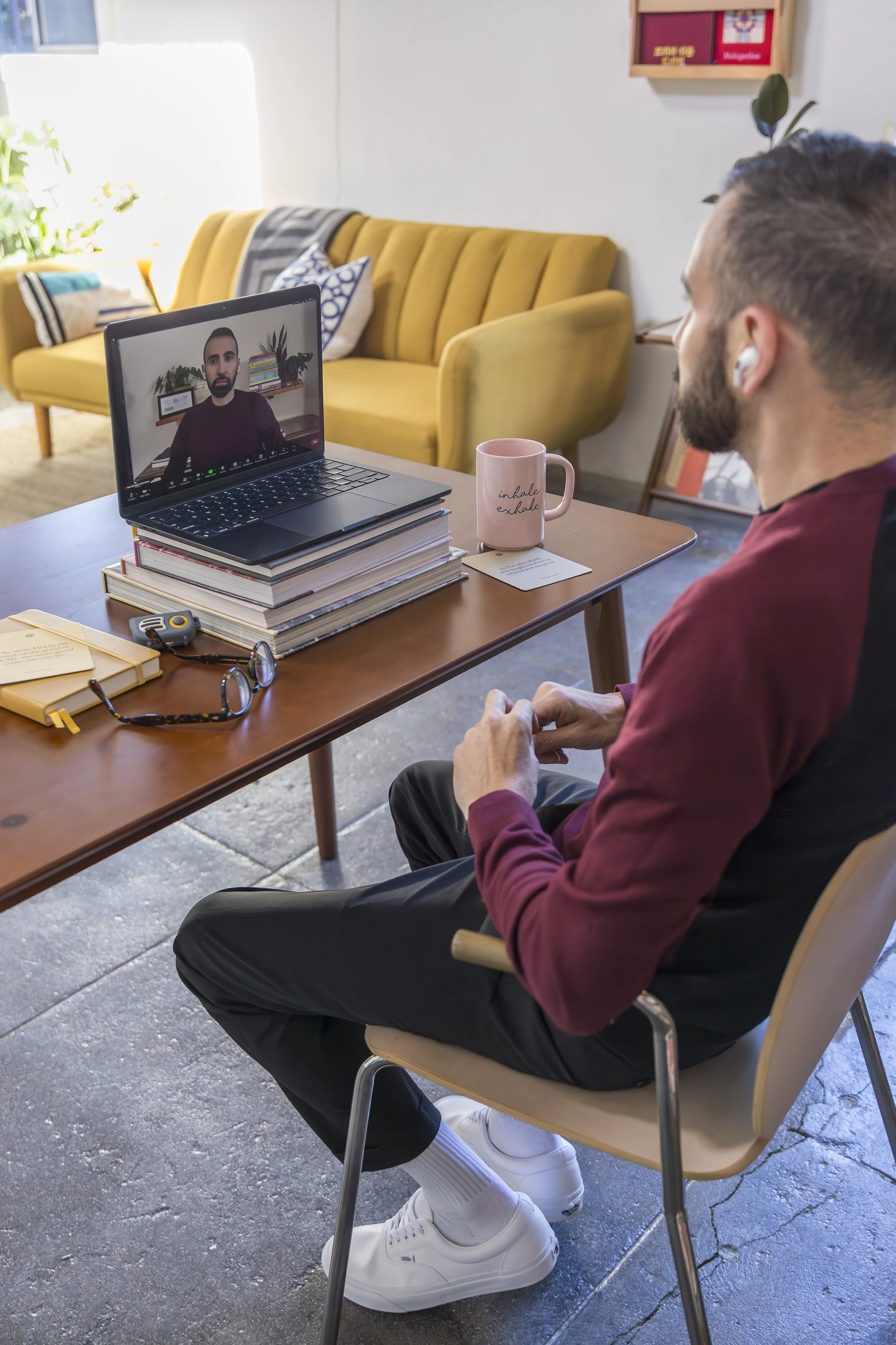 Alex Barragan, LGBTQ-affirming therapist in Los Angeles, smiling at his Westwood office desk