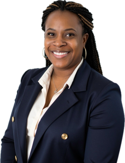 A smiling woman with braids, wearing a navy blazer and white shirt, posing against a black background.
