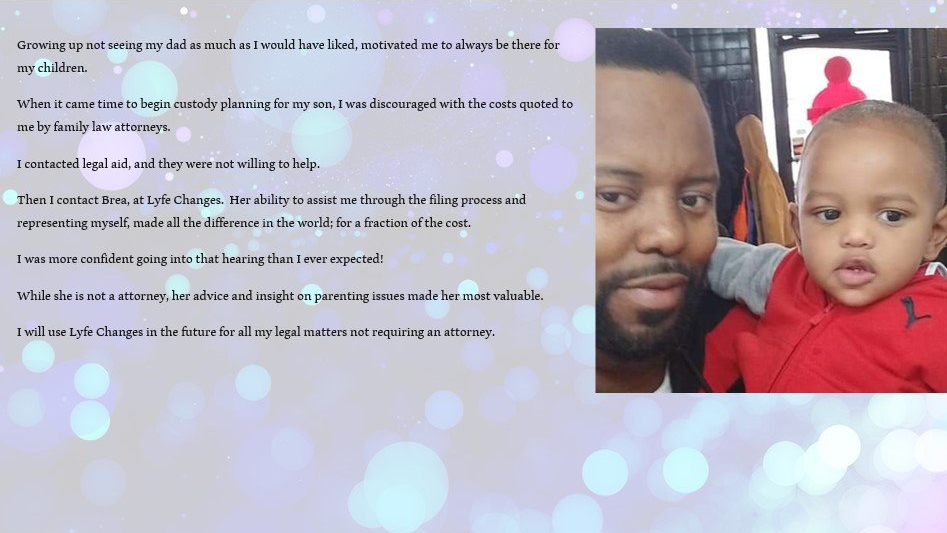 A man taking a selfie with a young child, both looking at the camera, in an indoor setting with a window behind them. The man has a beard and short hair, and the child is wearing a red jacket.