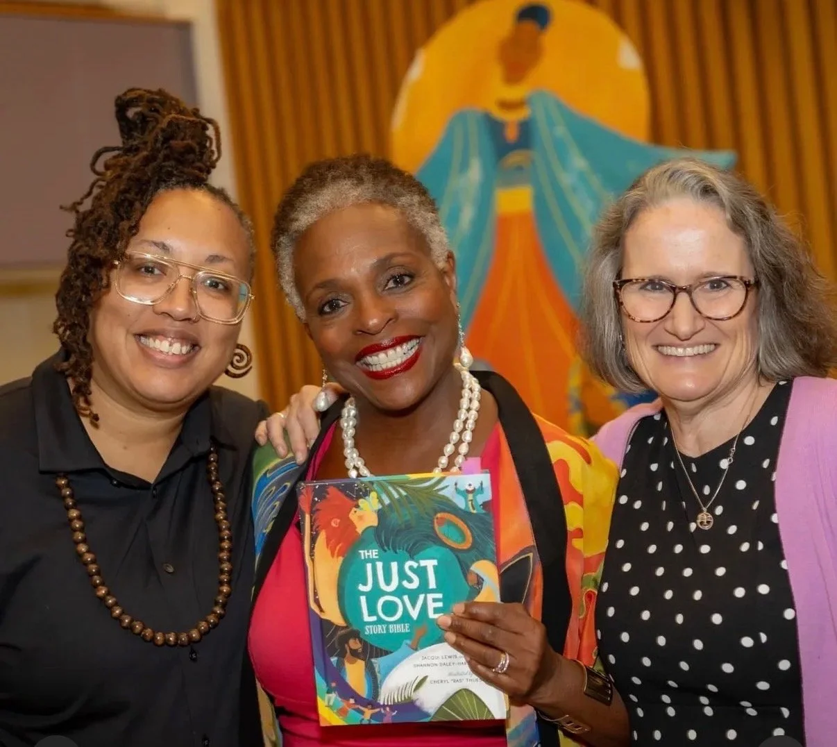 3 women with jacqui lewis holding a book