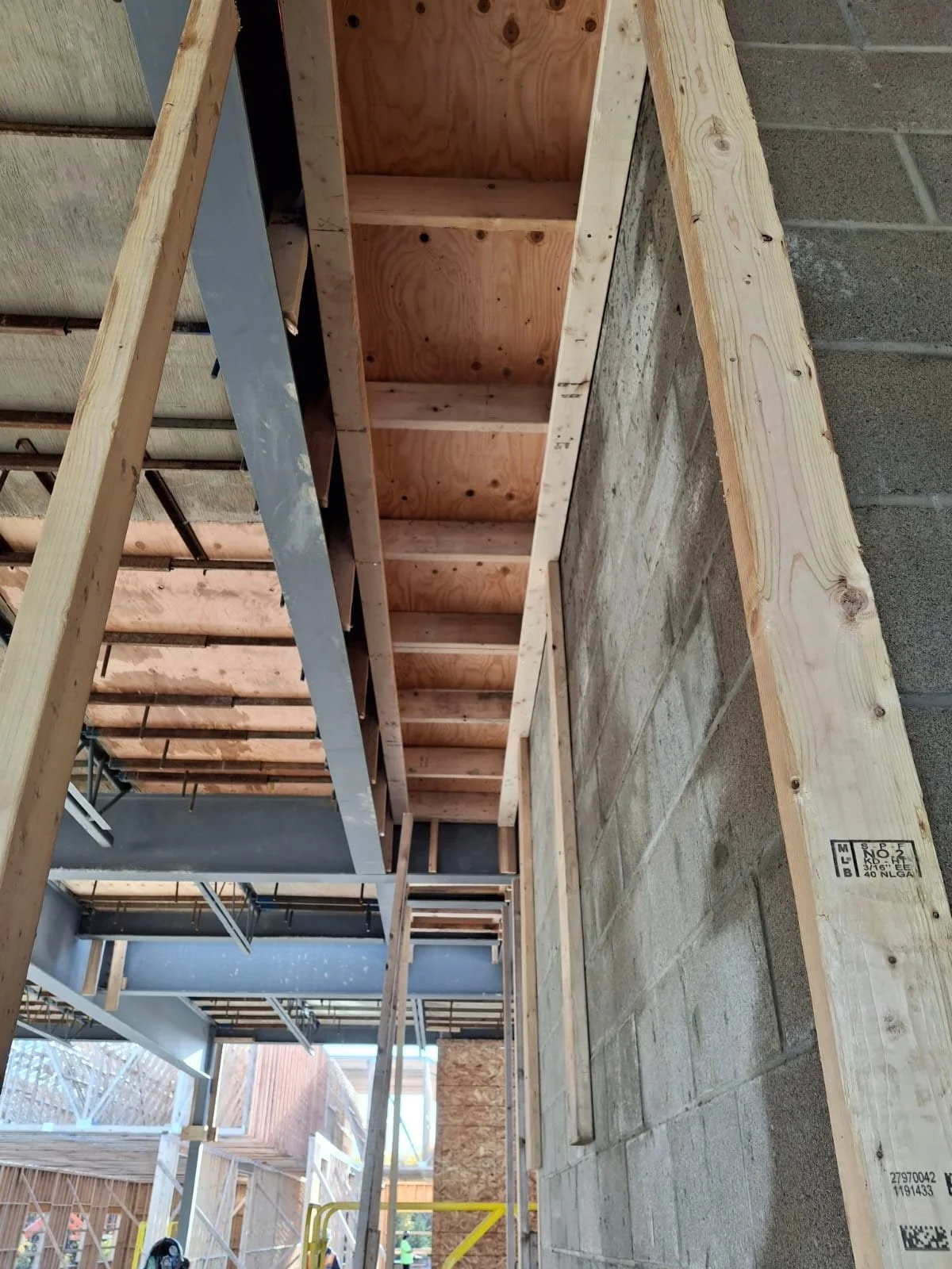 Construction site showing wooden framing and concrete wall.
