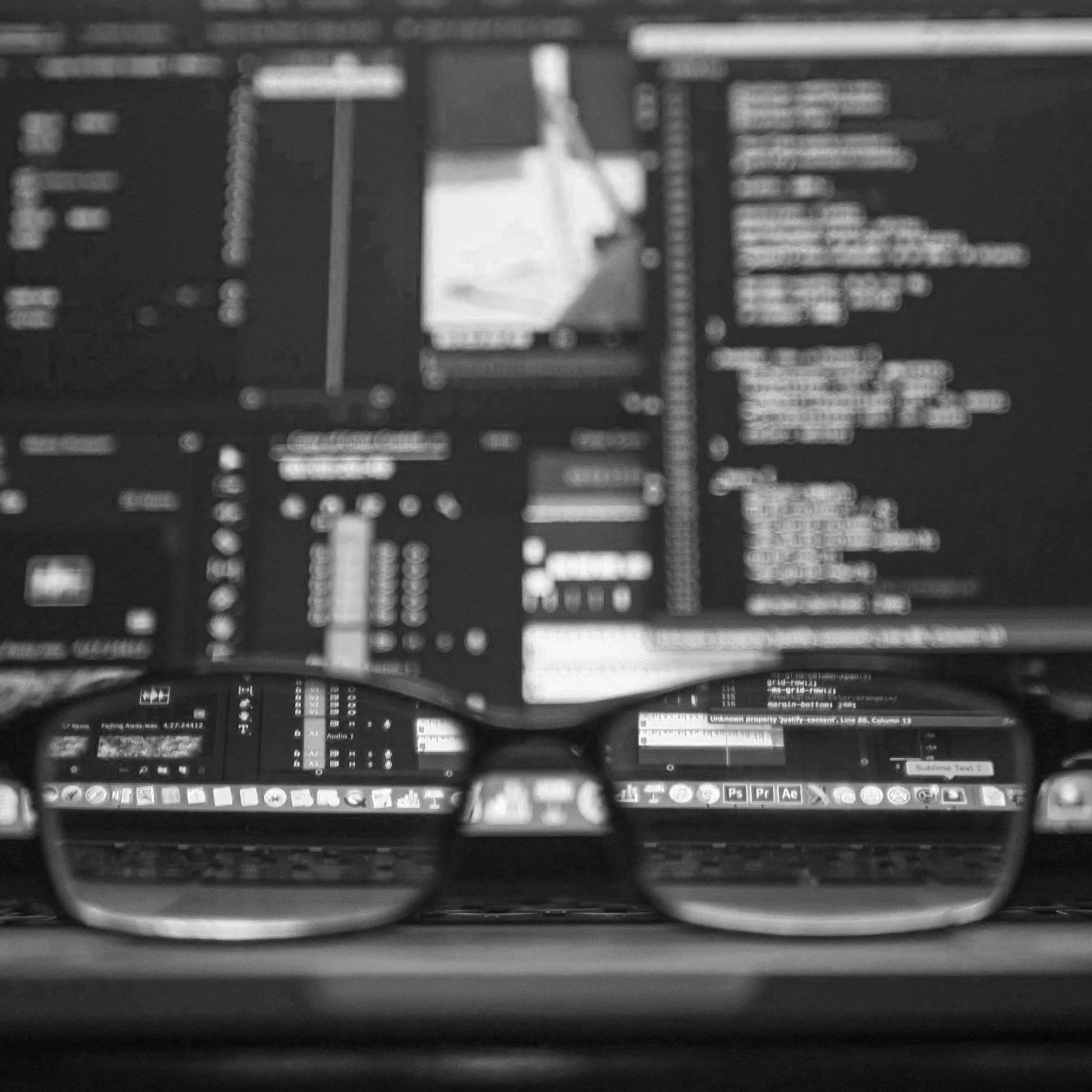 Glasses in front of a desktop computer from a person offering support.