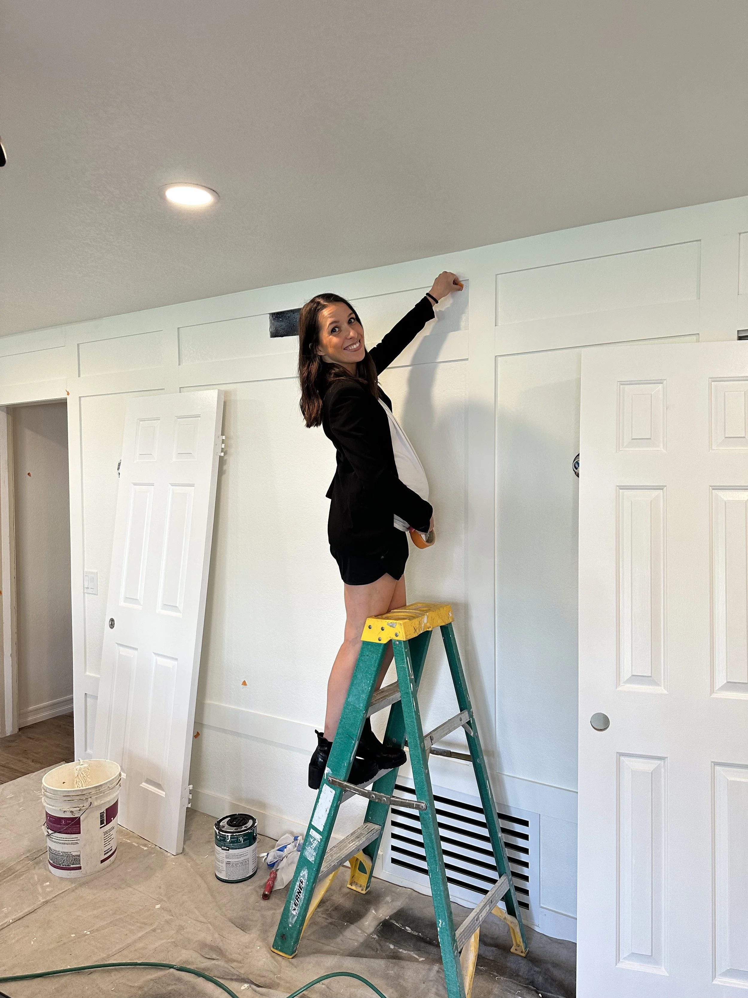 A newlywed couple walks together happily after their outdoor wedding ceremony, surrounded by friends and family throwing confetti, with a scenic green landscape and hills in the background.