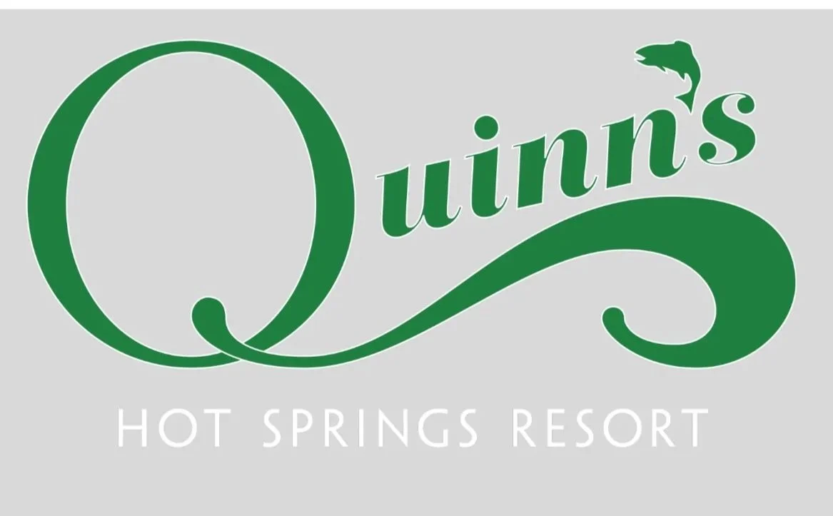 Logo for Quiin's Hot Springs Resort featuring green cursive text with a dolphin graphic, on a gray background.