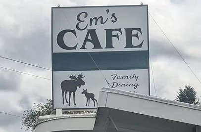 Sign for Em's Café with moose and moose calf silhouettes and text about family dining.